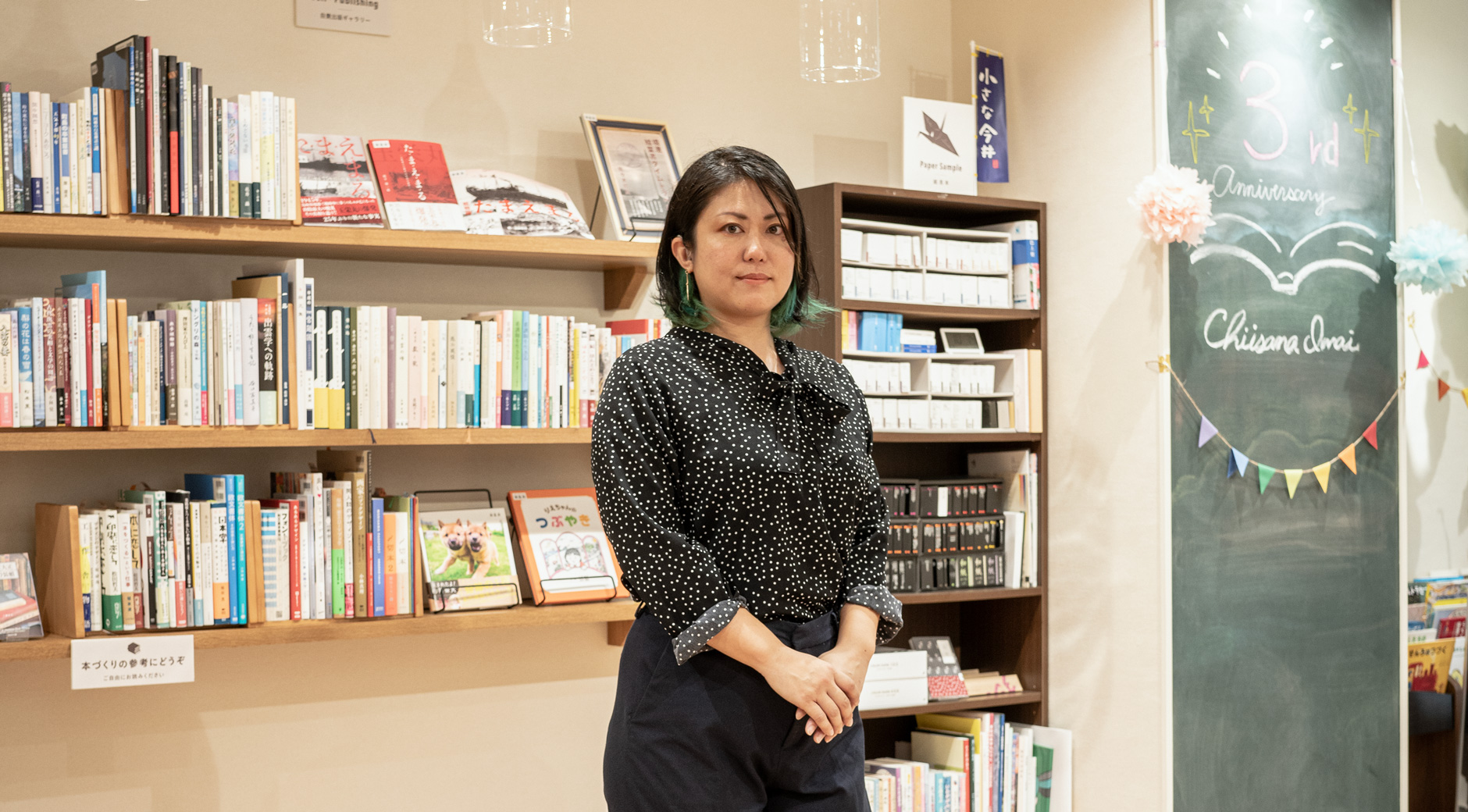 【画像】本棚の前に立つ上野智美さん