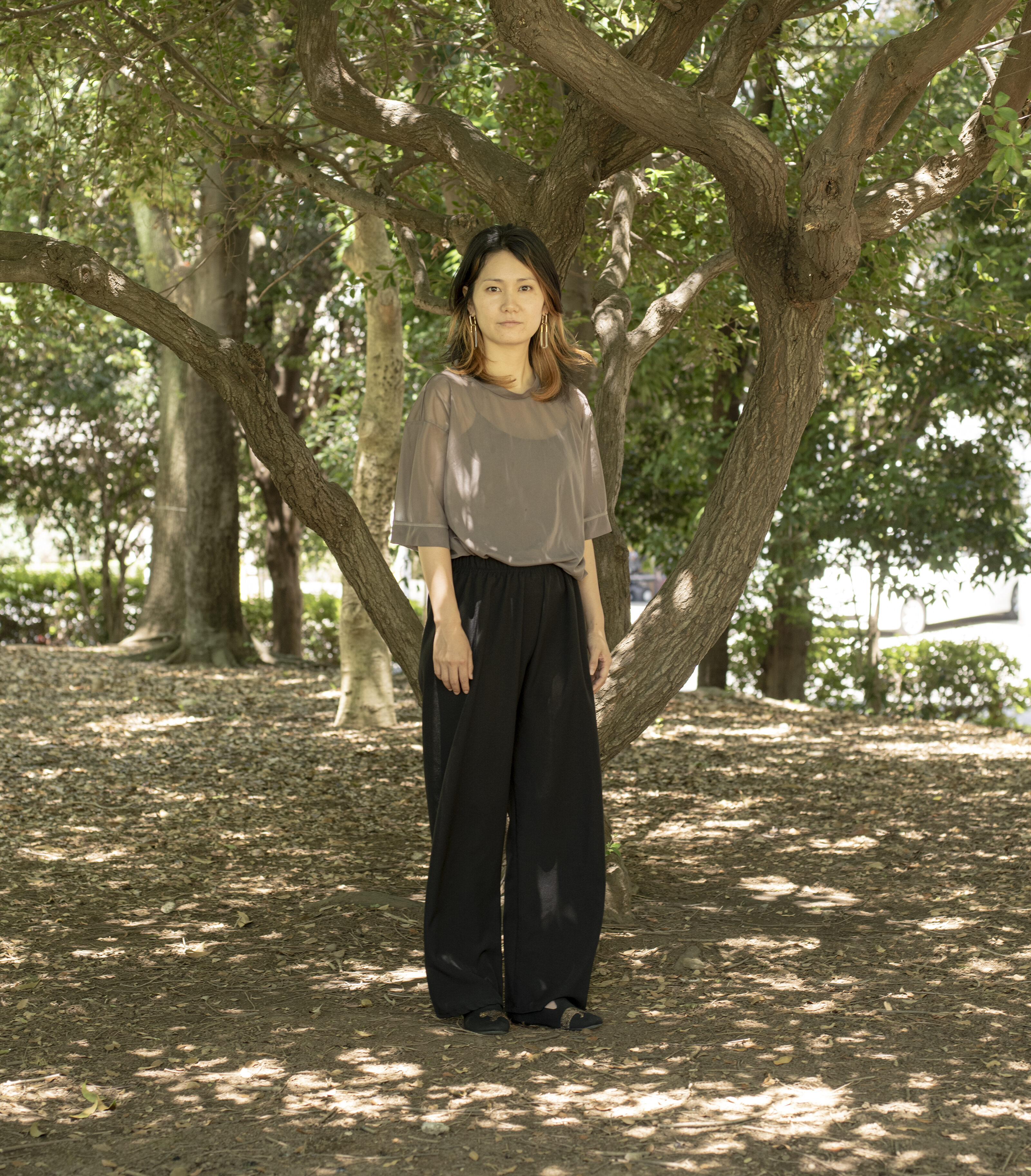 【写真】木漏れ日がさす場所に立つなぐもさん