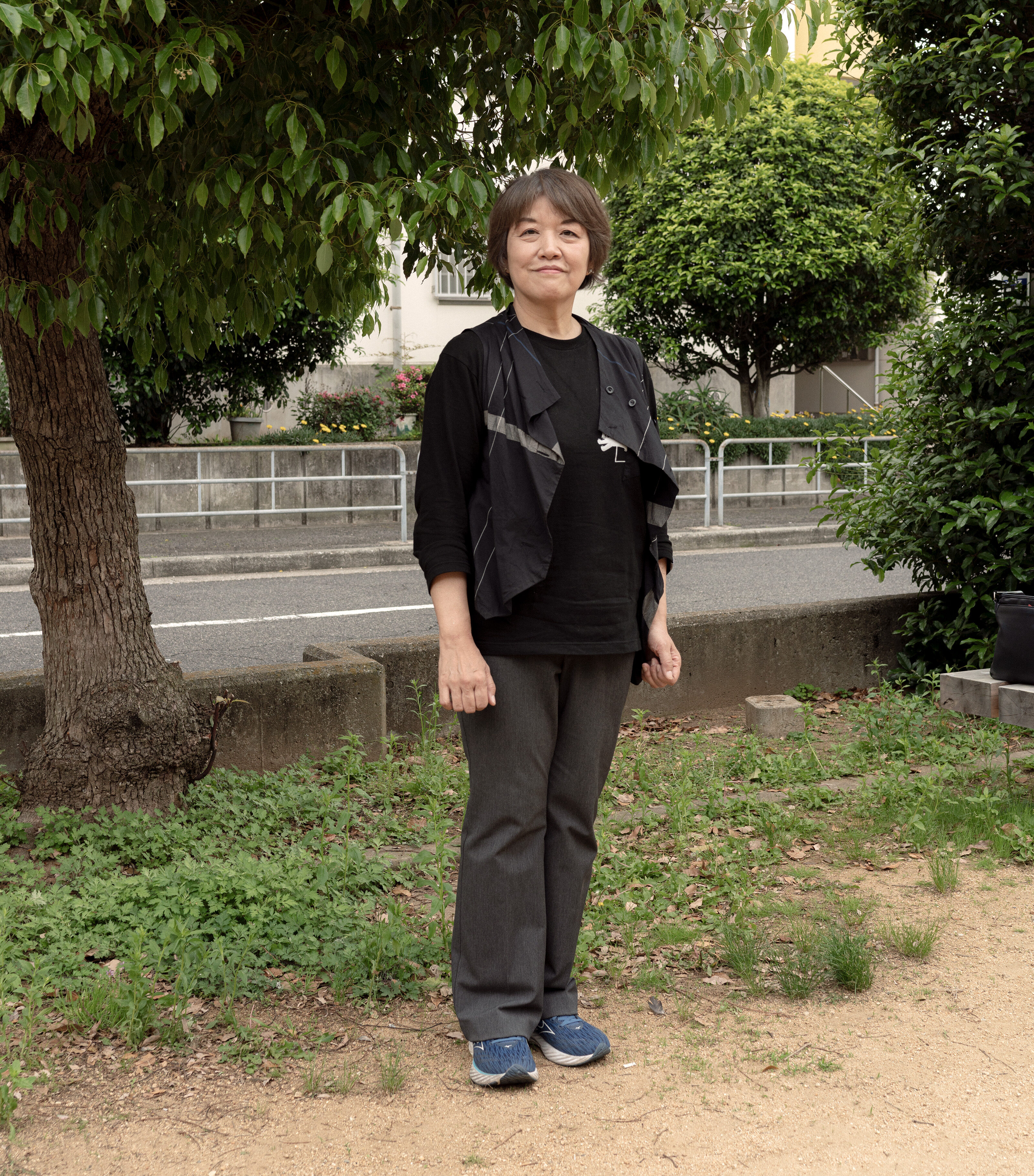 【写真】長袖のTシャツにズボン、歩きやすそうな靴を履いて立つはらださん