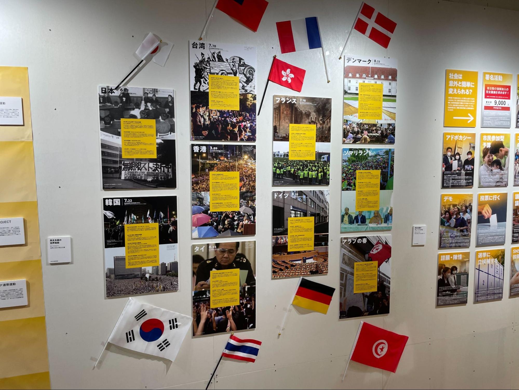 【写真】台湾、フランス、デンマーク、香港などの国名や国旗と、関連する写真やエピソードが壁に展示られている