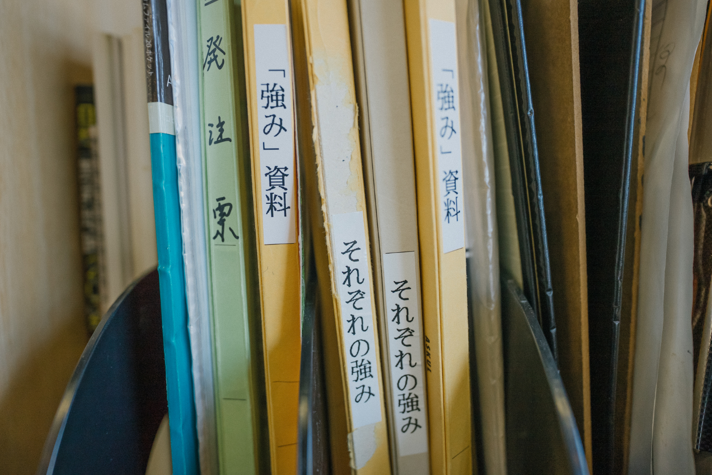 【写真】強み資料、それぞれの強み、などラベルが貼られたファイルが棚に並ぶ