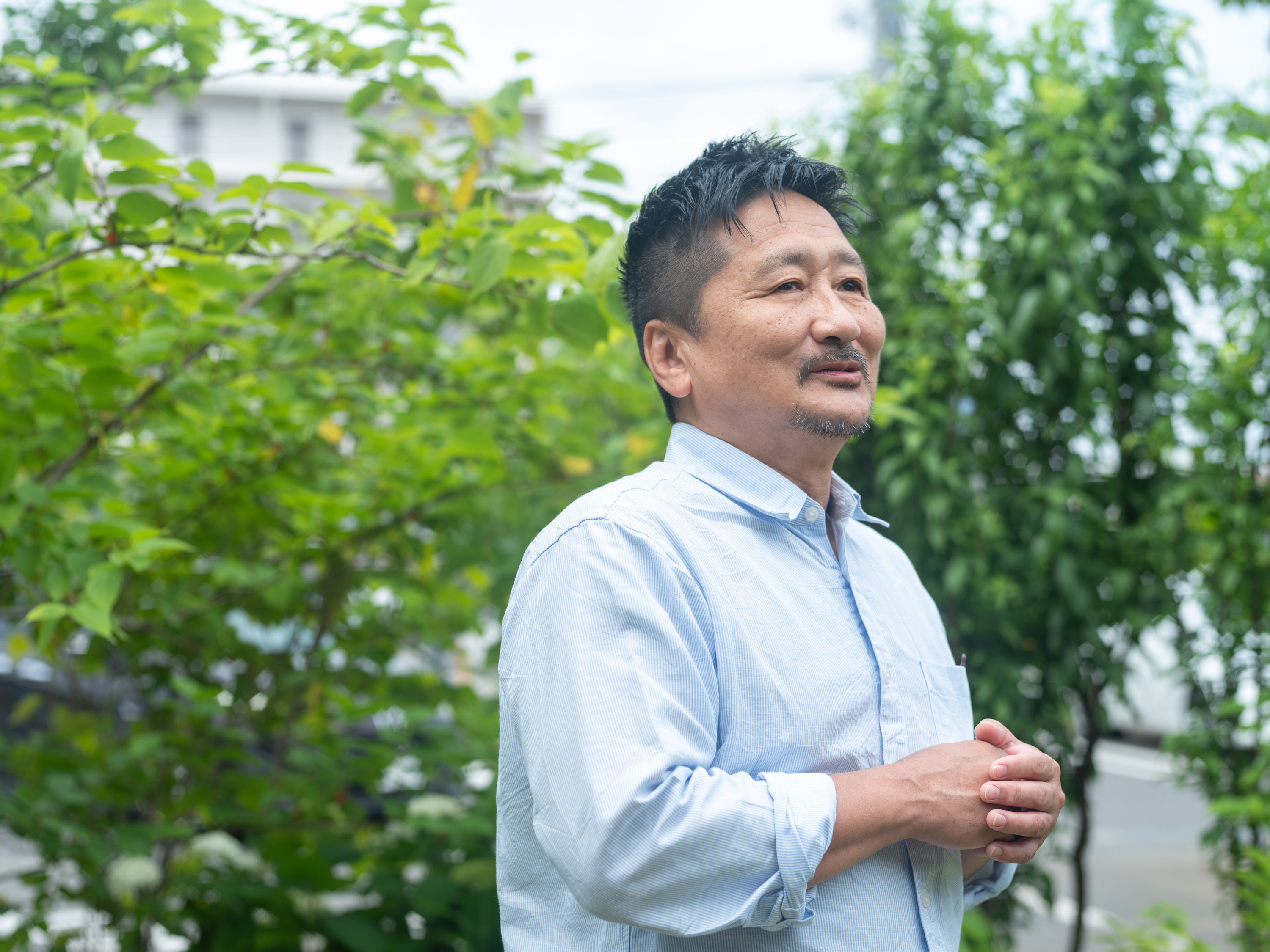 【写真】からだの前で両手を合わせ、インタビューにこたえるはぎわらさん