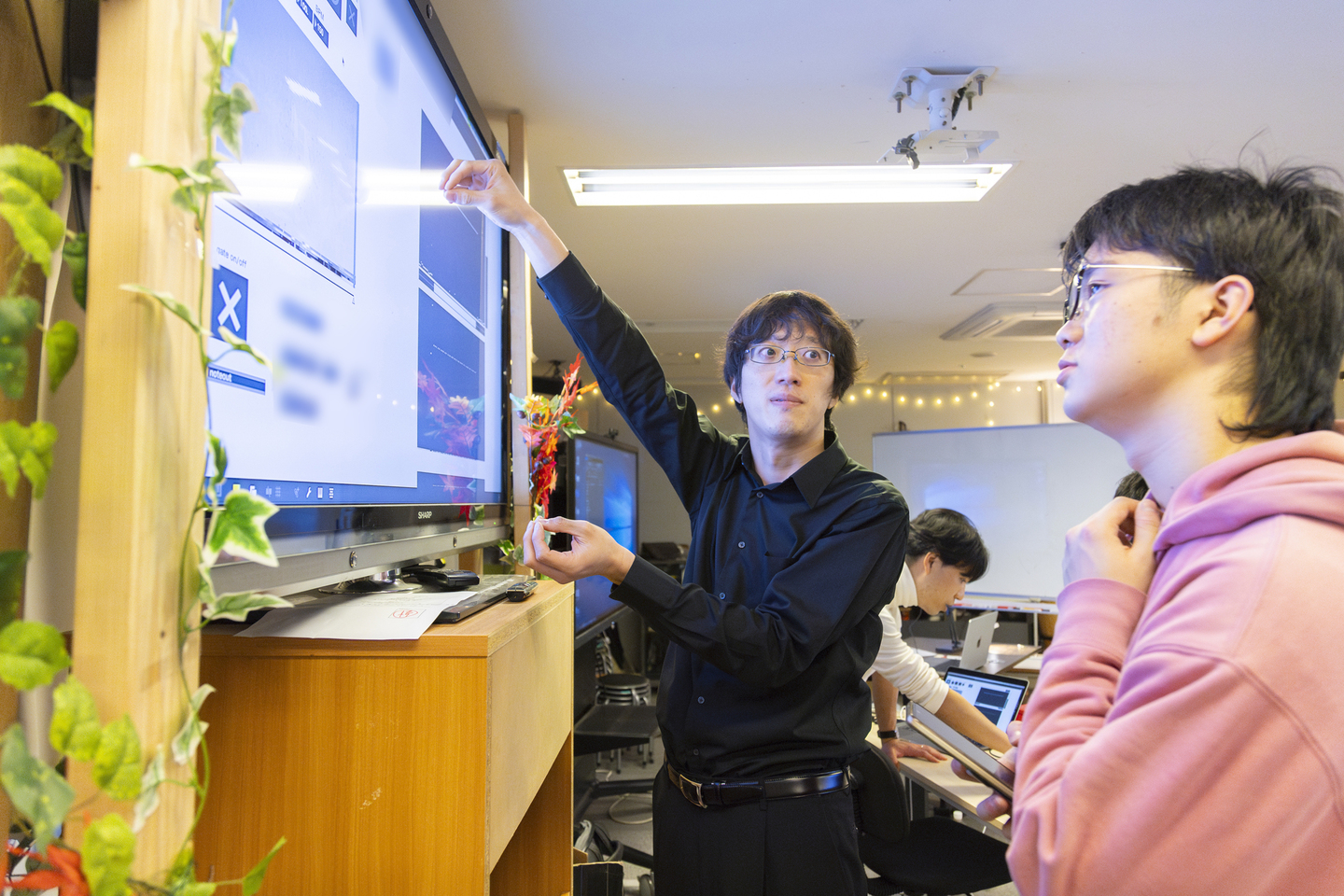 【写真】大きなモニター画面を前に語りあう人々
