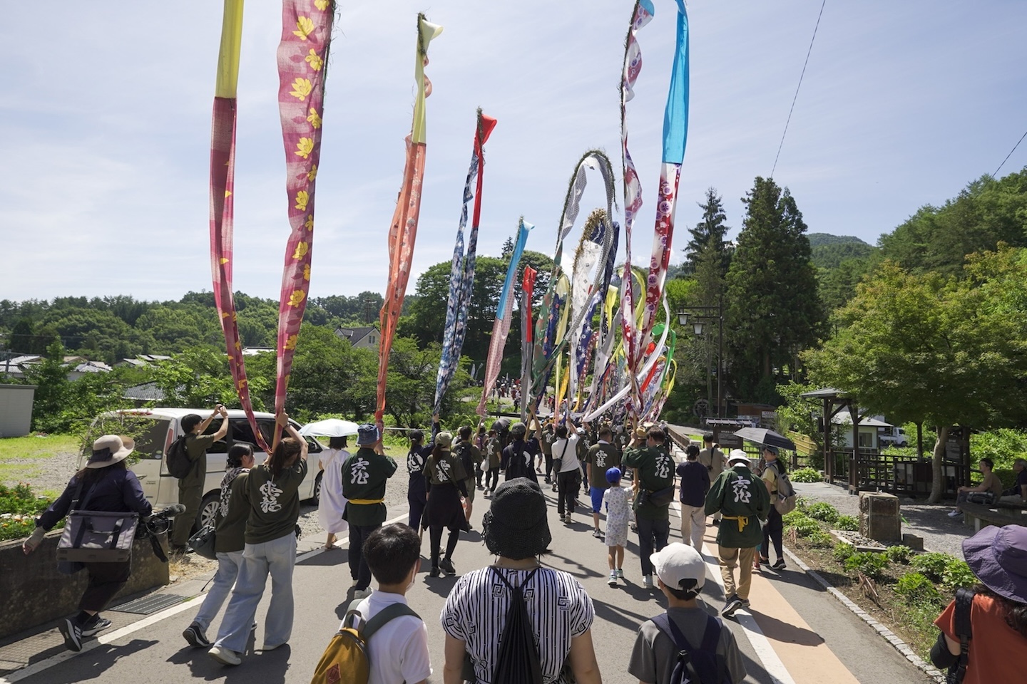 幟を持って歩く人たちの後ろ姿