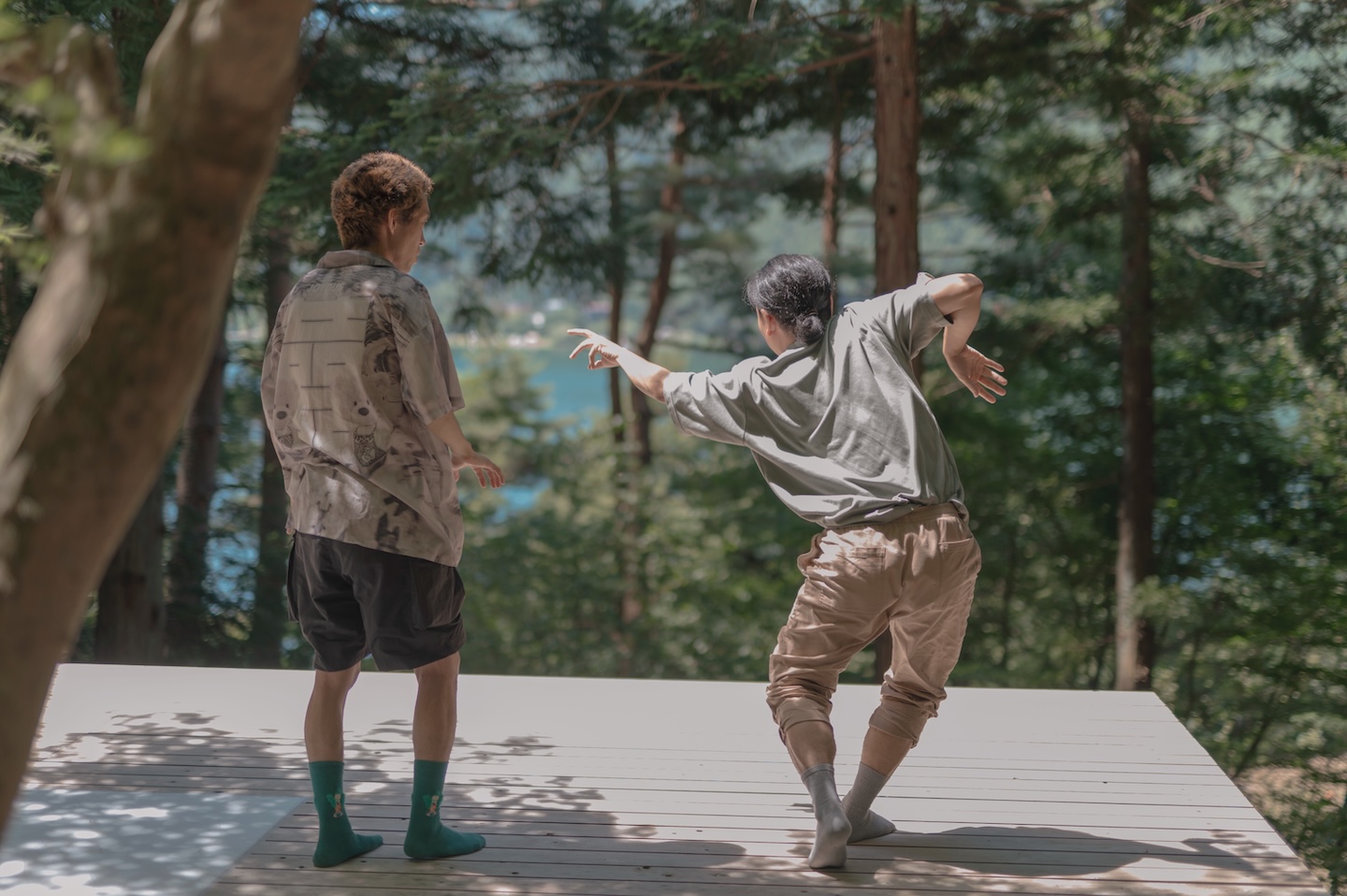 二人の人が隣同士で立ち、右側の人の踊りを左側の人が見ている