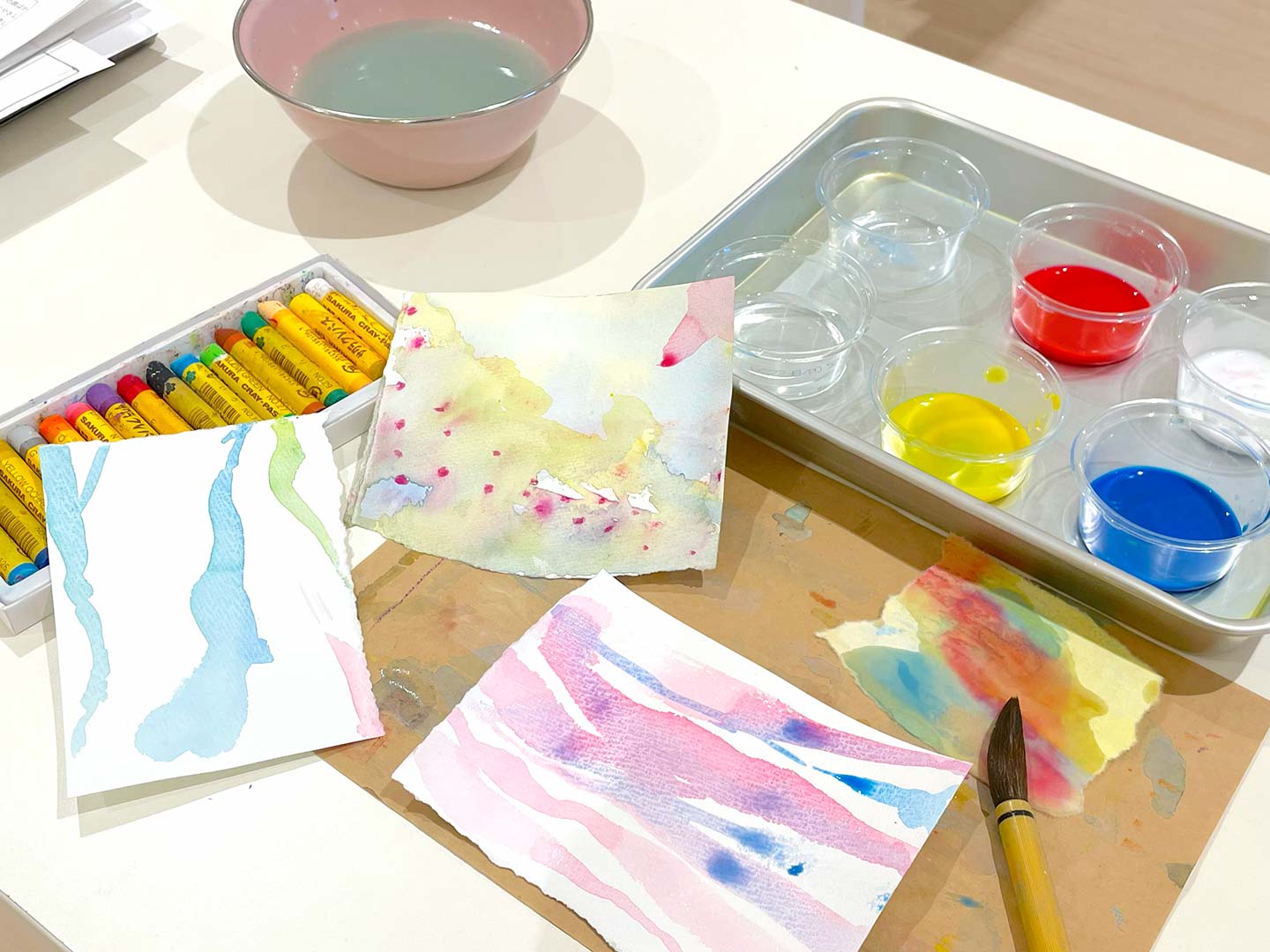水絵の具によるアート表現の画用紙が3枚ほど置かれている写真。