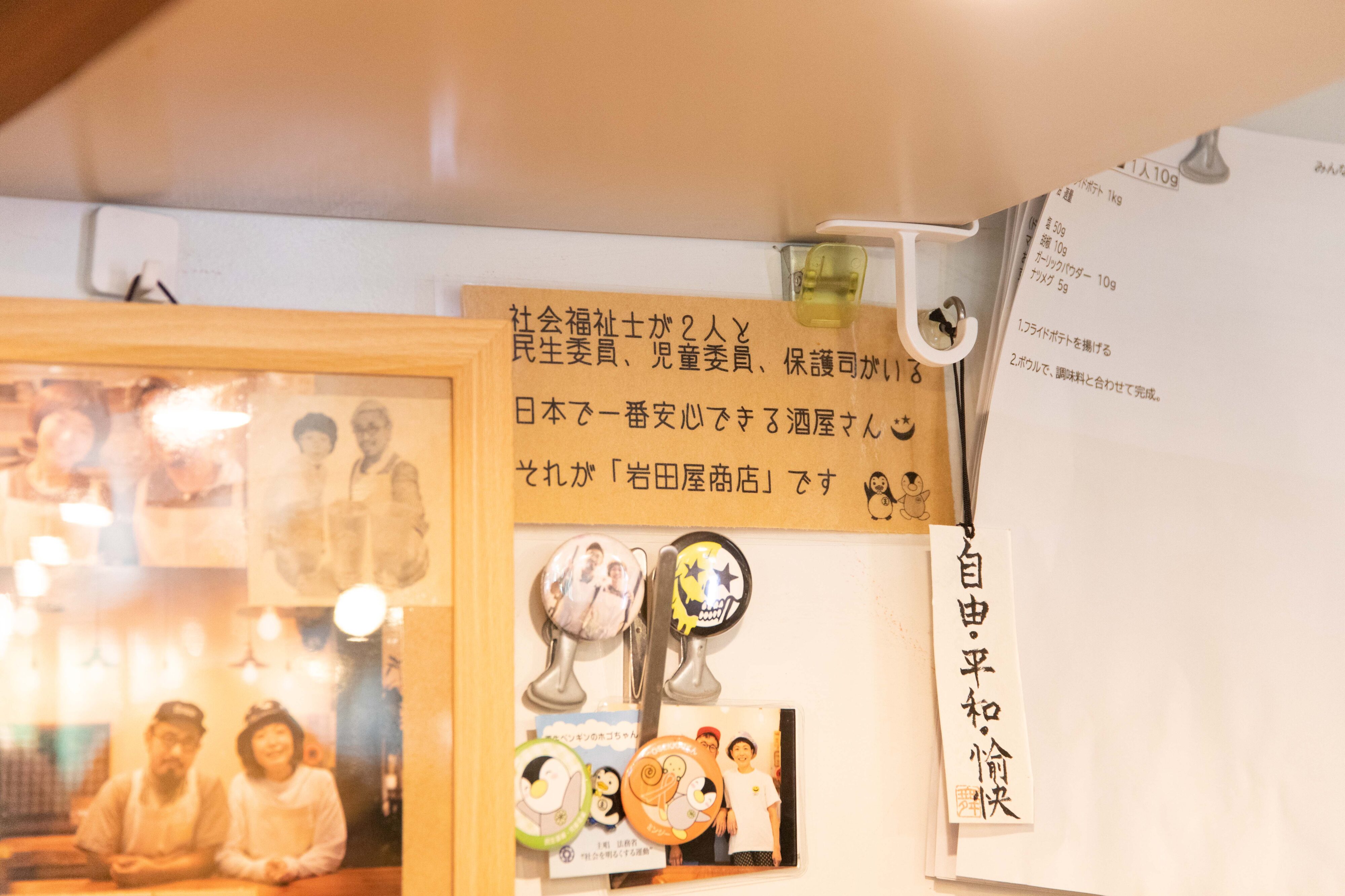 【写真】貼り紙に、社会福祉士がふたりと民生委員、児童委員、保護司がいる日本で一番安心できる酒屋さんそれが「岩田屋商店」ですと書かれている。