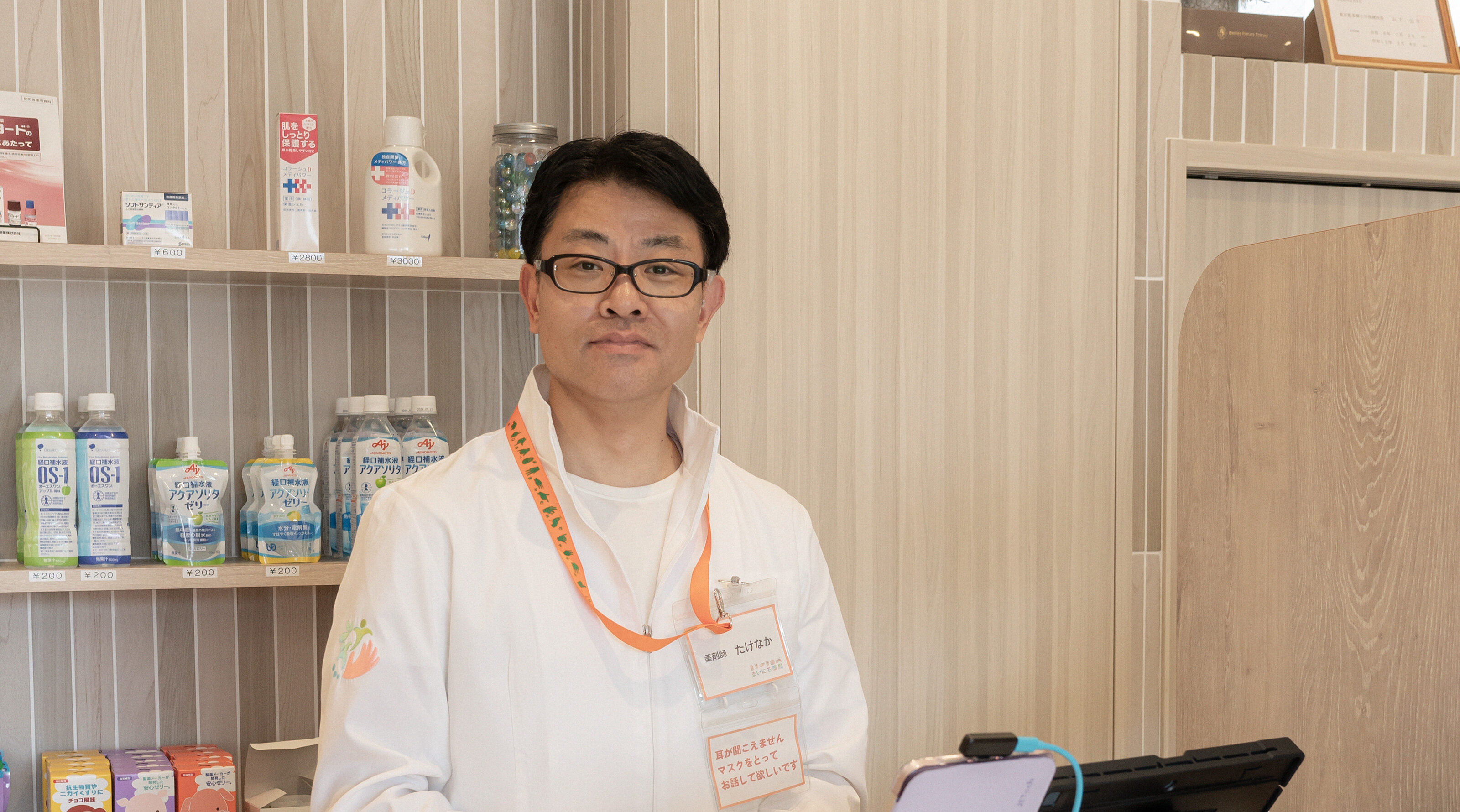 【写真】カウンターの前、黒い眼鏡をかけ、白いシャツを着てこちらをみるたけなかさん