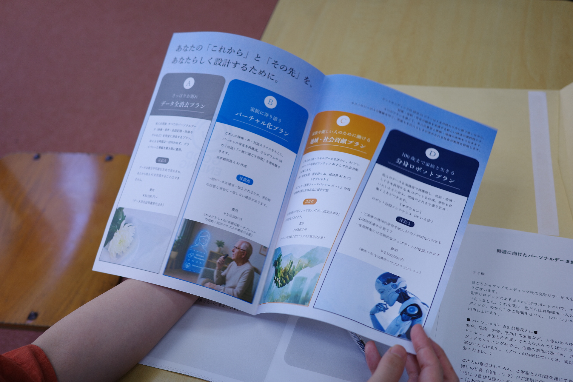 【写真】見開きのリーフレット。バーチャル化プラン、分身ロボットプランなどの文字が読める