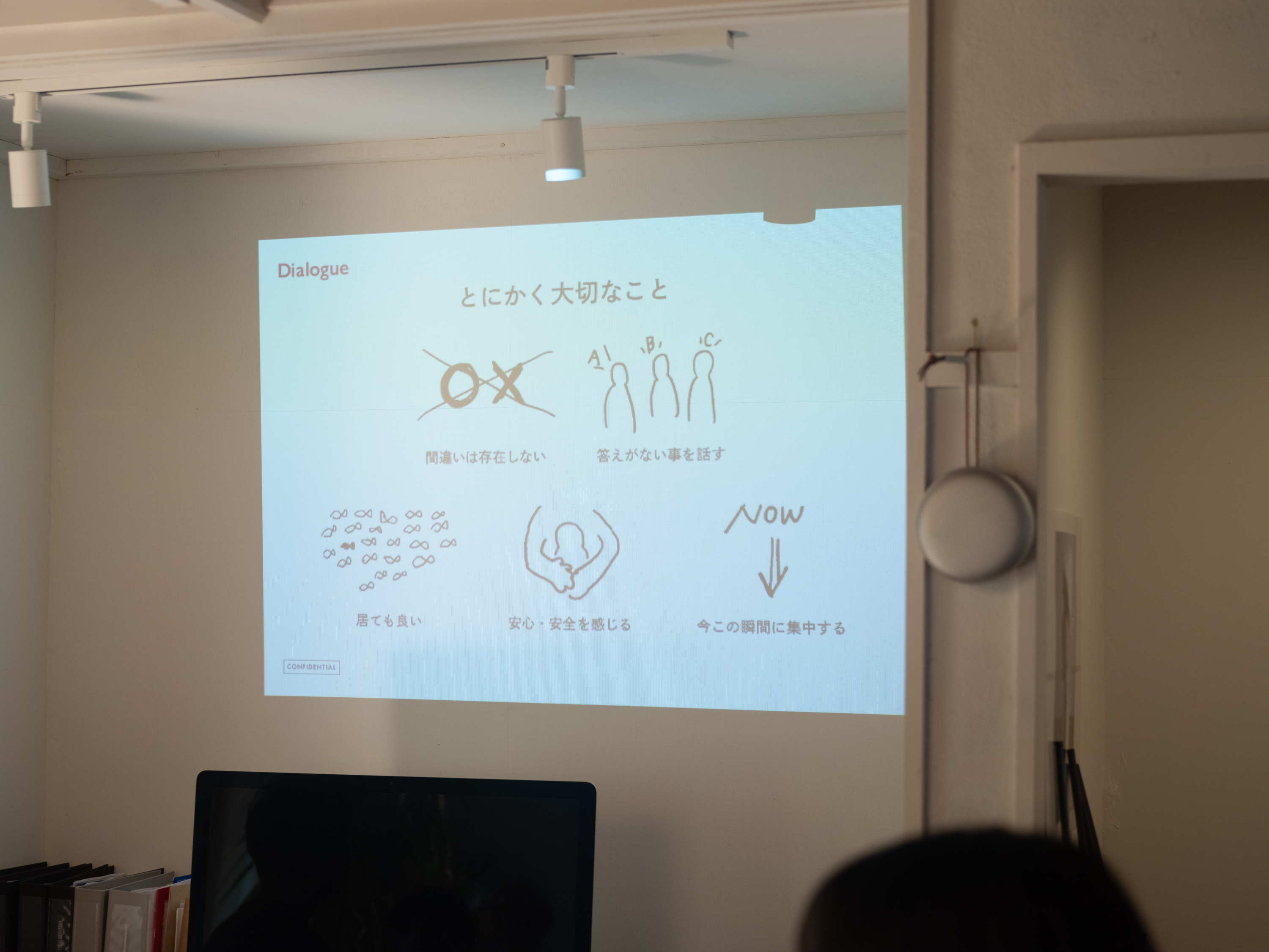 【画像】壁に投影されたスライド。タイトルには「とにかく大切なこと」と書かれていて、「間違いは存在しない」「答えがない事を話す」「居ても良い」「安心・安全を感じる」「今この瞬間に集中する」ということばがイラストとともに書かれている。