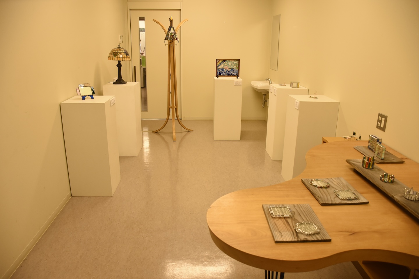 白い部屋に、ステンドグラスなどの作品が展示されている