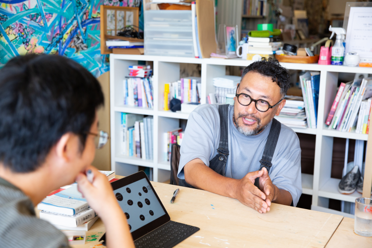 【写真】青山さんに手振りを交えて語りかける小松さん