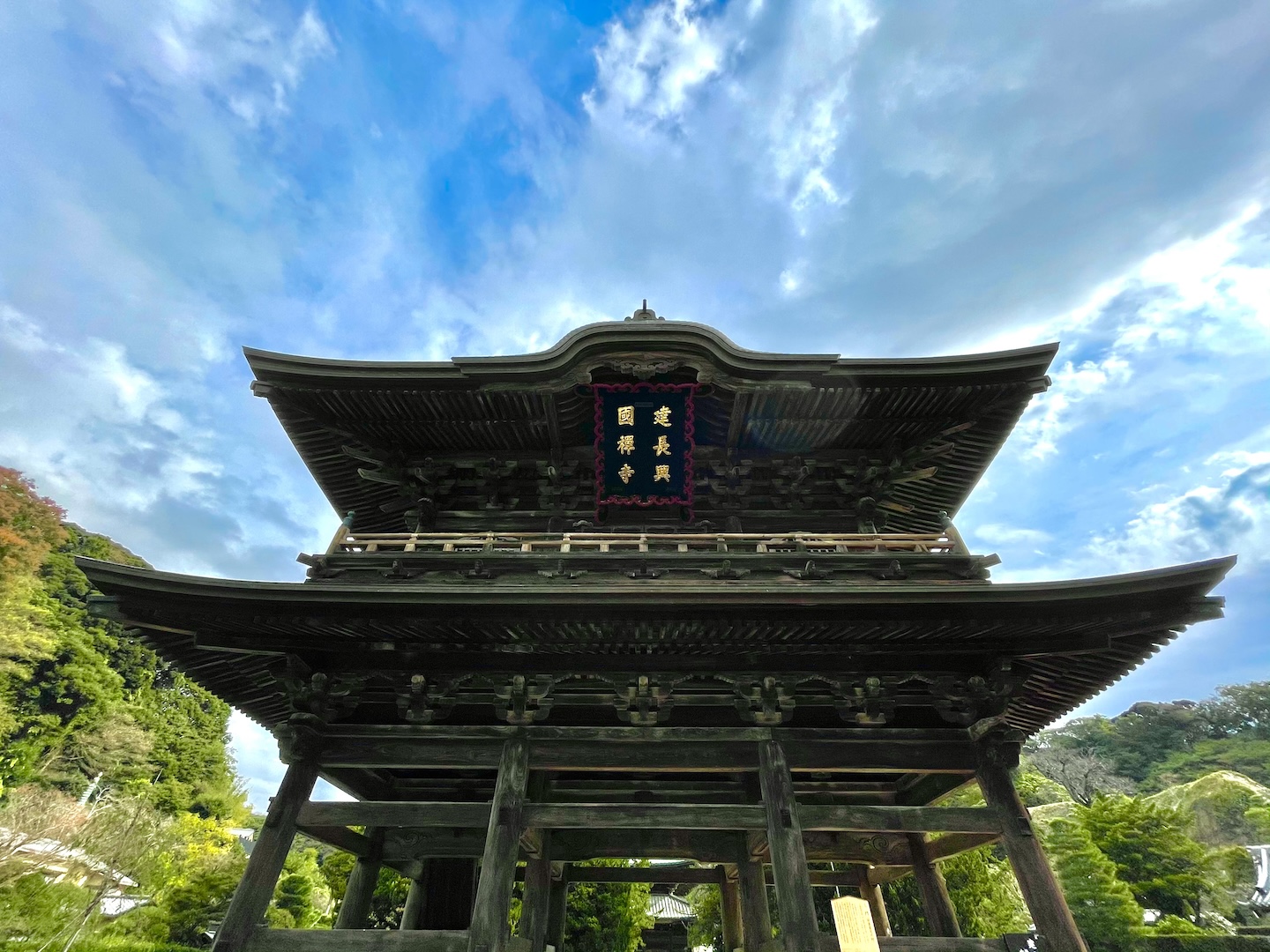 青空をバックにした、寺の大きな門の写真