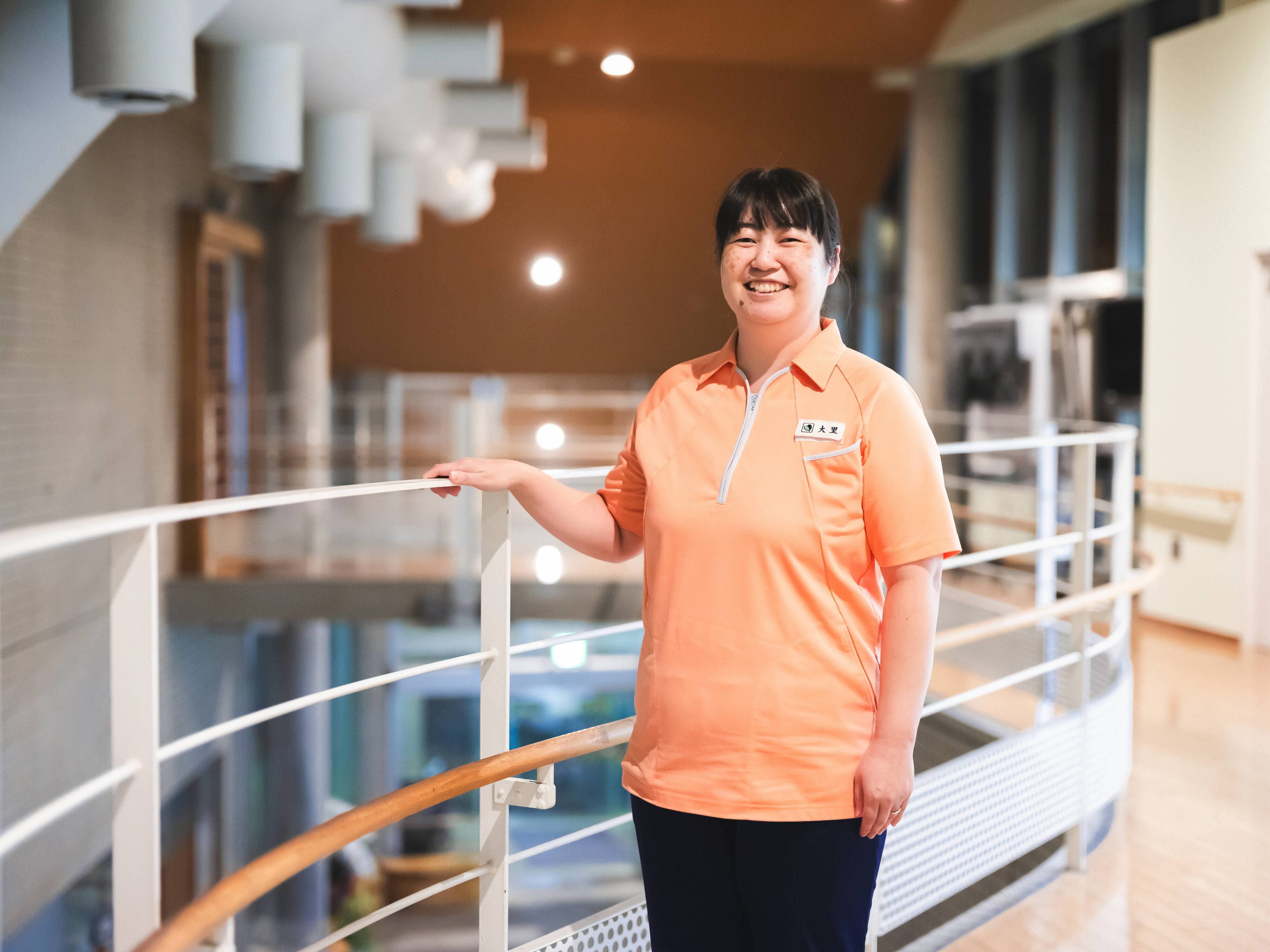 【写真】オレンジのユニフォームを着て、こちらに微笑みかけるおおさとさん