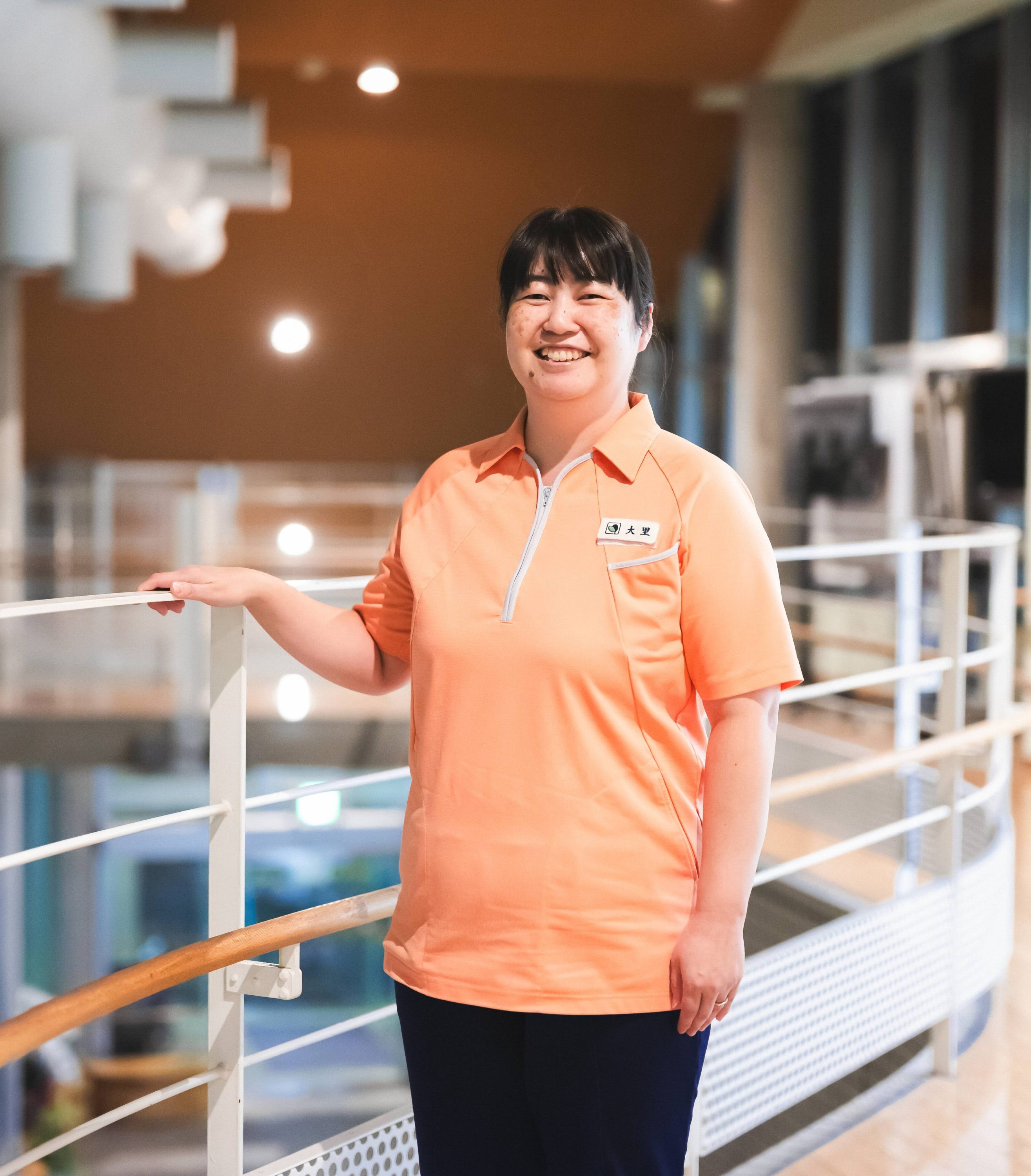 【写真】オレンジのユニフォームを着て、こちらに微笑みかけるおおさとさん