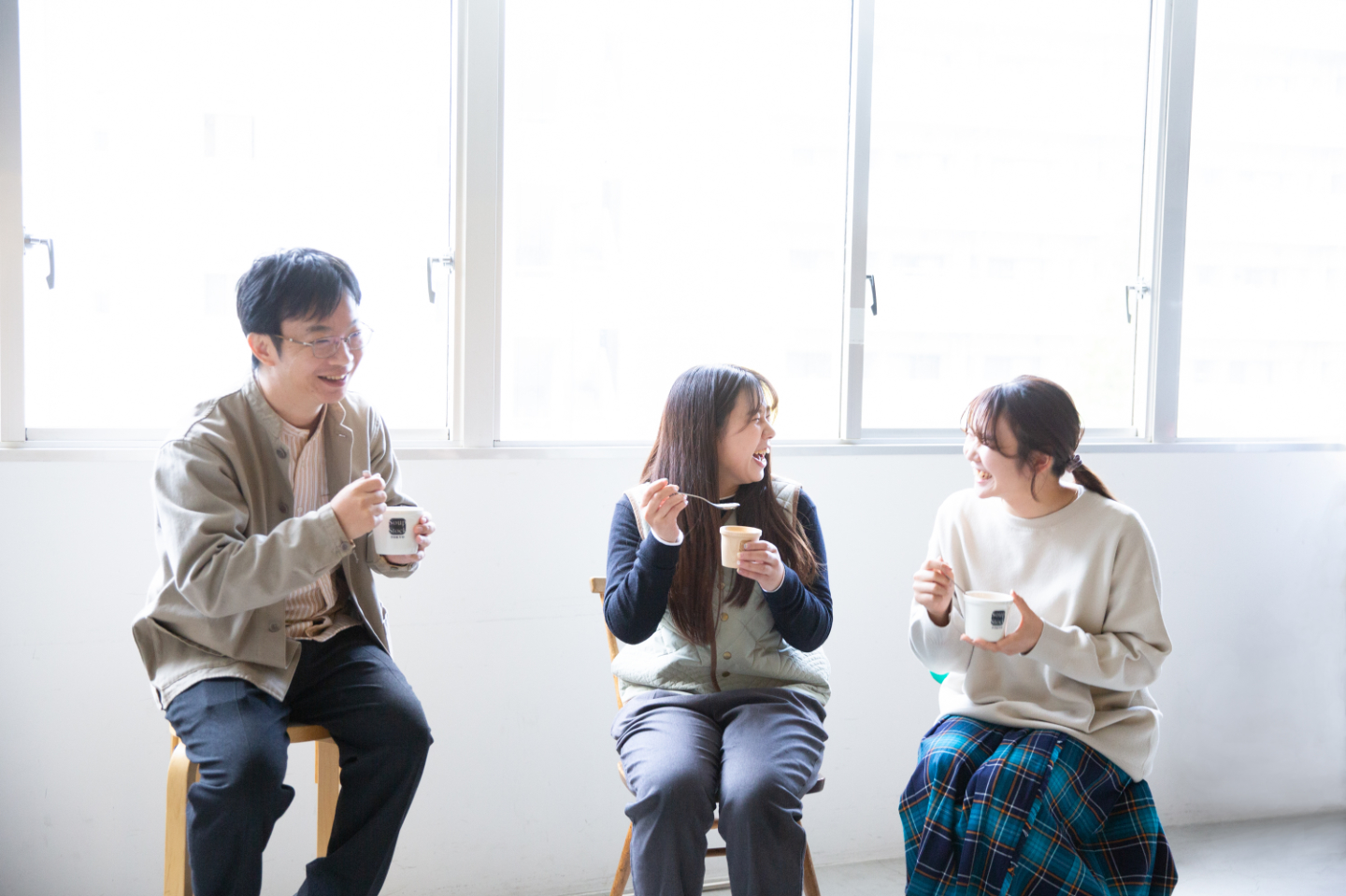 【写真】明るい窓際で三人が小さなカップのスープを食べながら笑顔で談笑している
