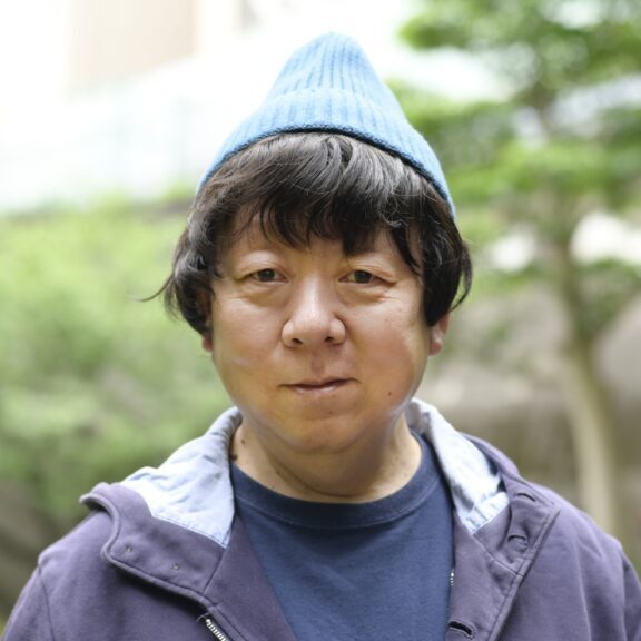 【写真】青のニット帽を被って笑う新澤さん