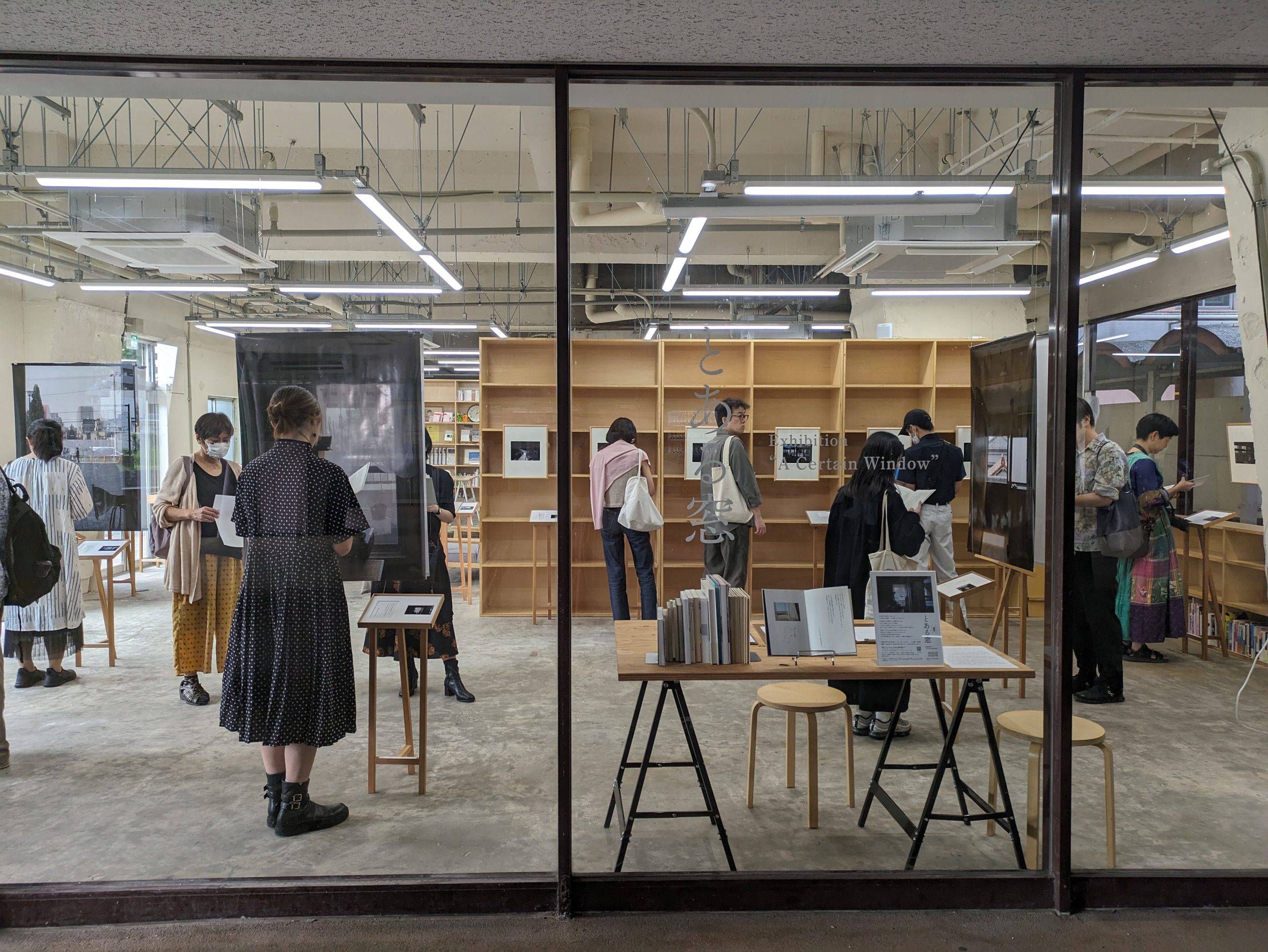 【写真】ガラス張りの広い空間を外から見ている。たくさんの人が展示を眺めている