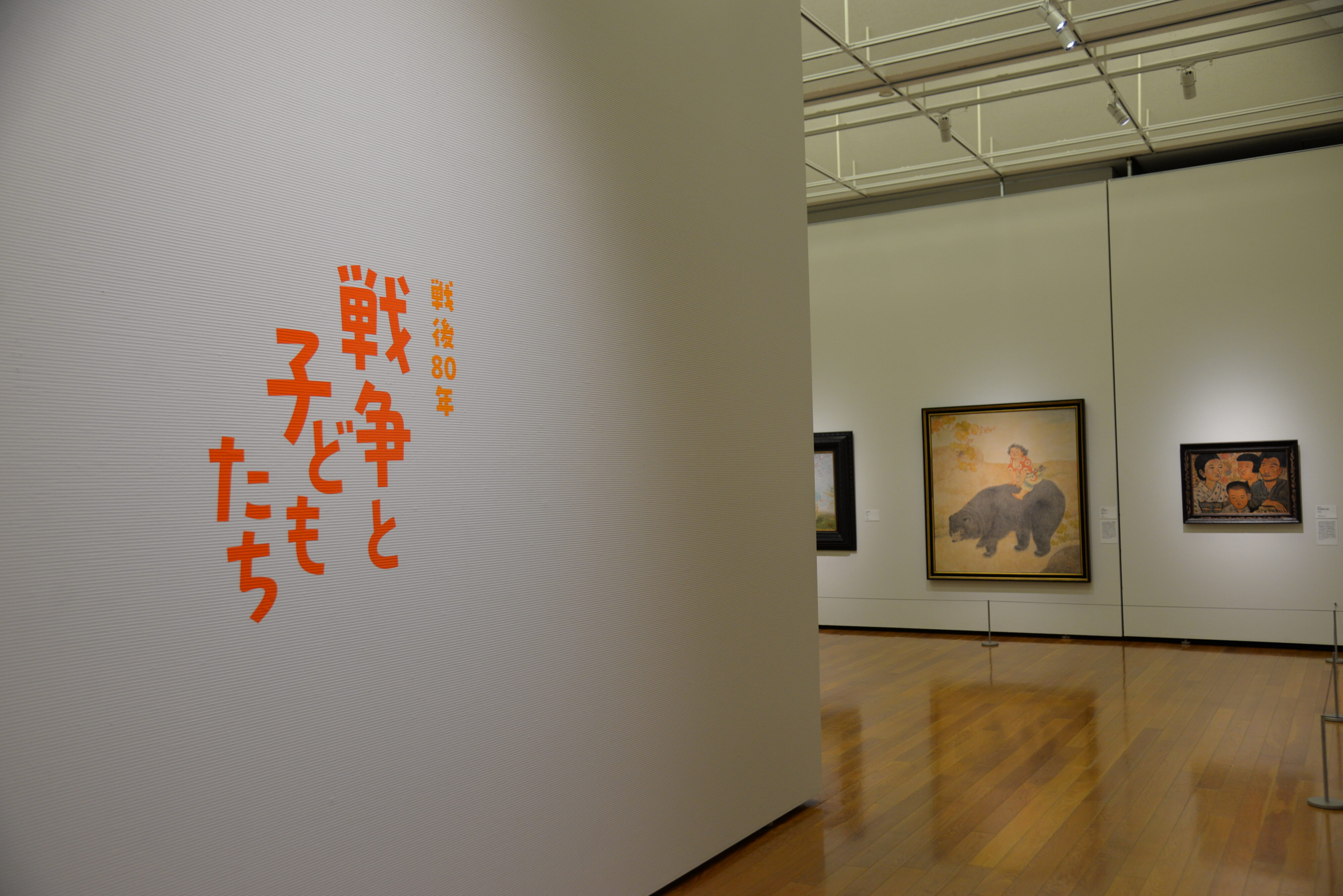 【写真】展覧会場の入り口。戦争と子どもたち、と書かれた大きなサインが壁にある
