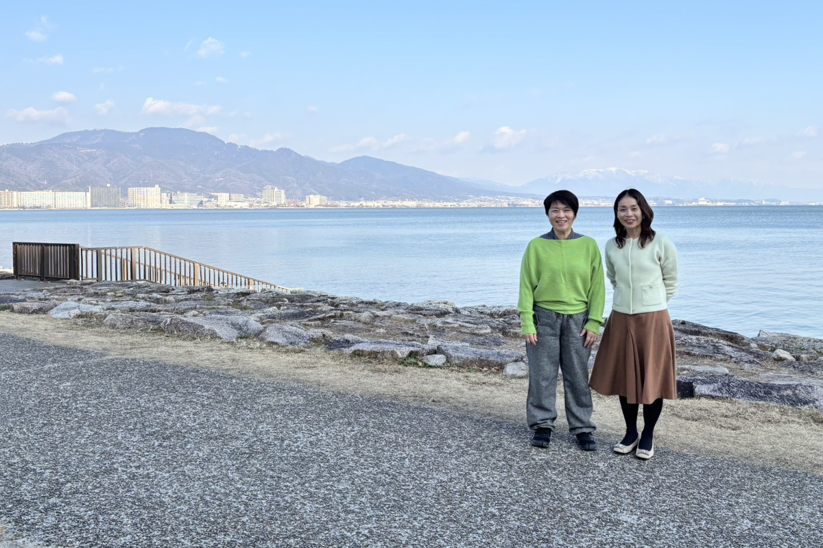 海を背景に2人が並んで立っている写真