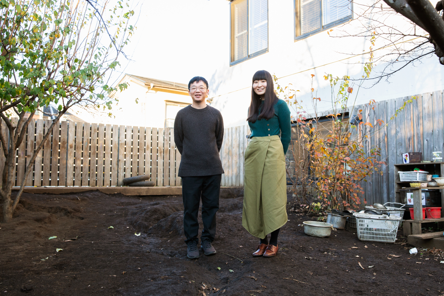 【写真】園庭に経つ寺尾さんと青山さん。背後には木製のフェンスや落葉した木々があり、素朴で自然な環境が広がっている