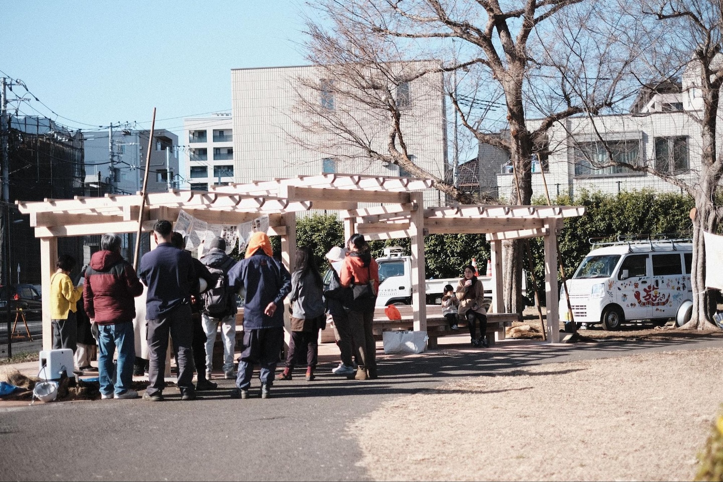 写真。デッキの周りに、人が集まって作業している様子