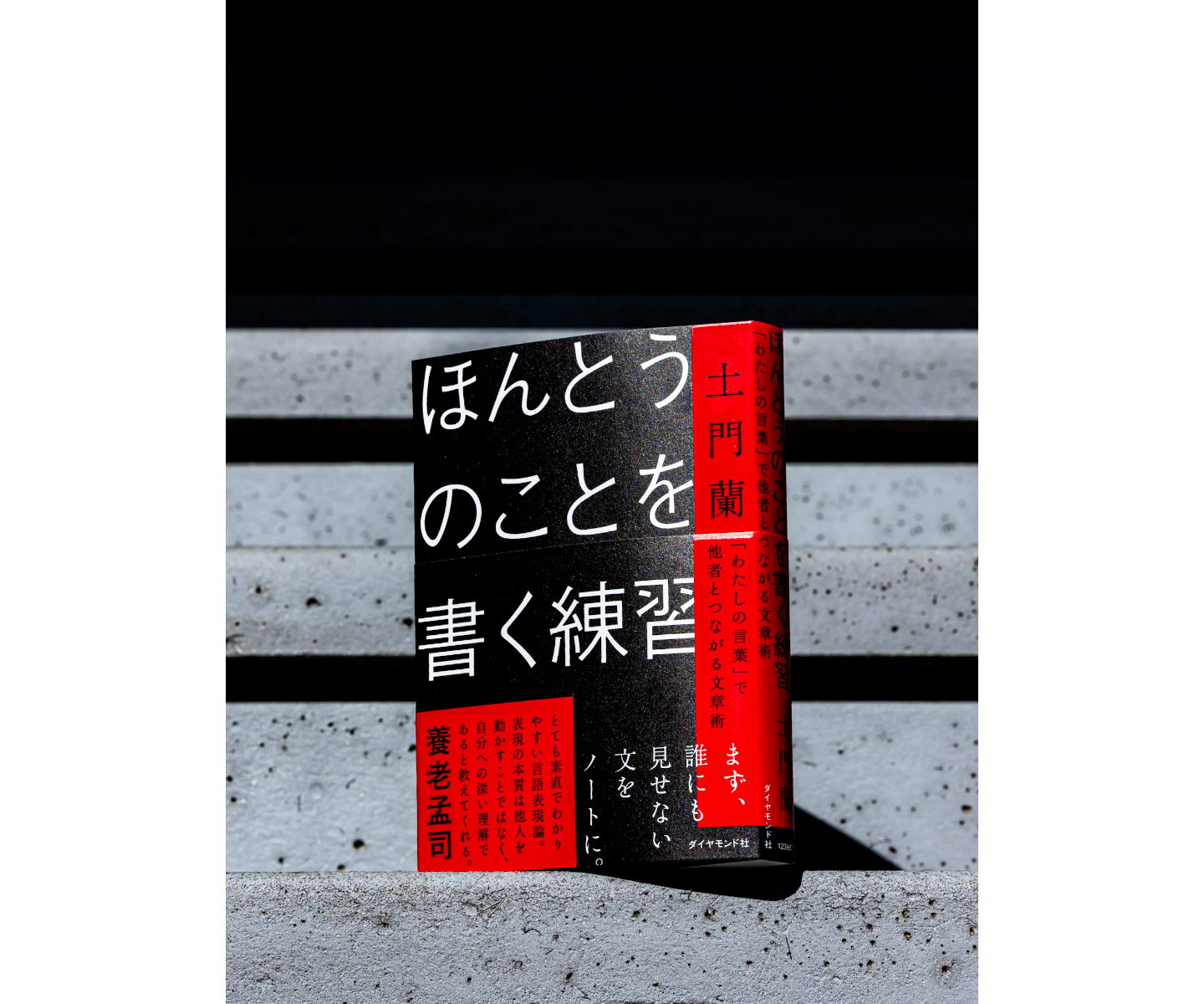 【写真】ベンチに置かれた本。暗闇の中で光が表紙を照らしている