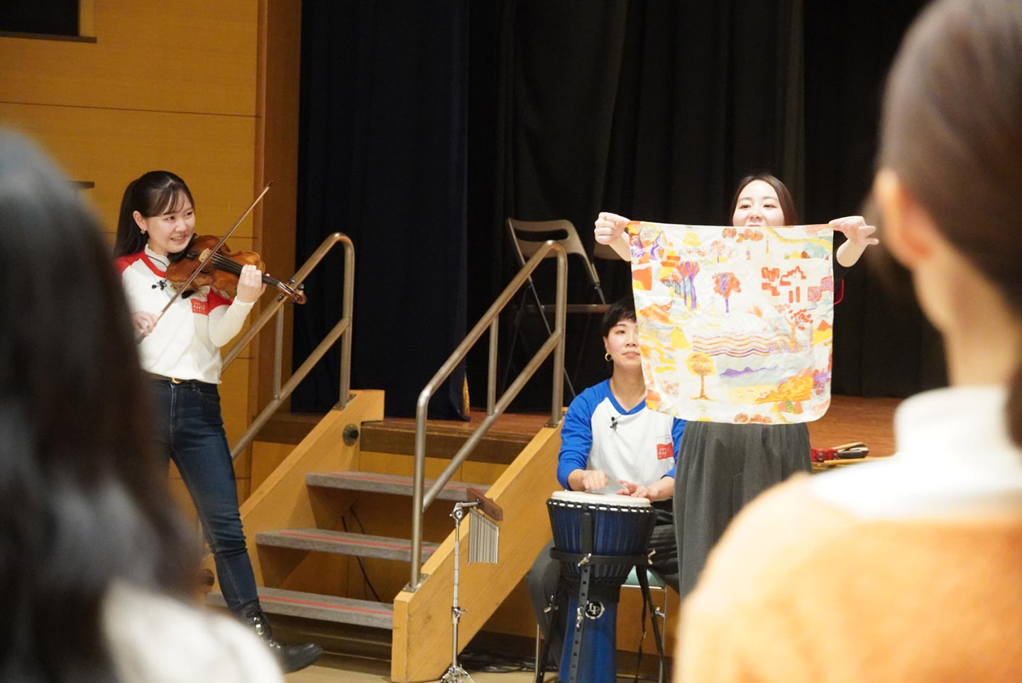 バイオリンやジャンベ（民族楽器）を奏でる人や、ハンカチを広げてパフォーマンスをする人などの写真。