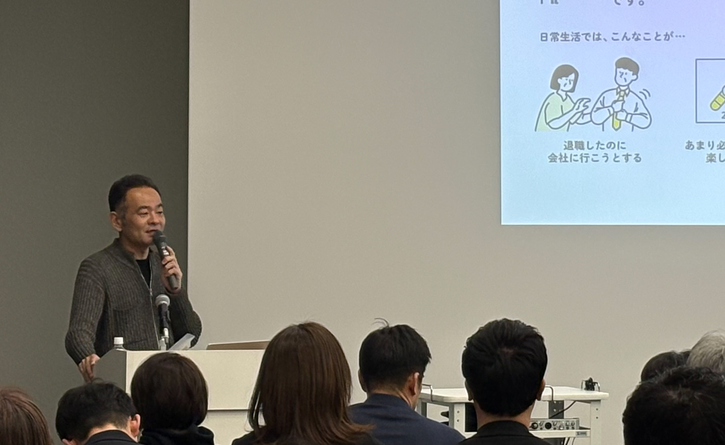 マイクを握って話している様子