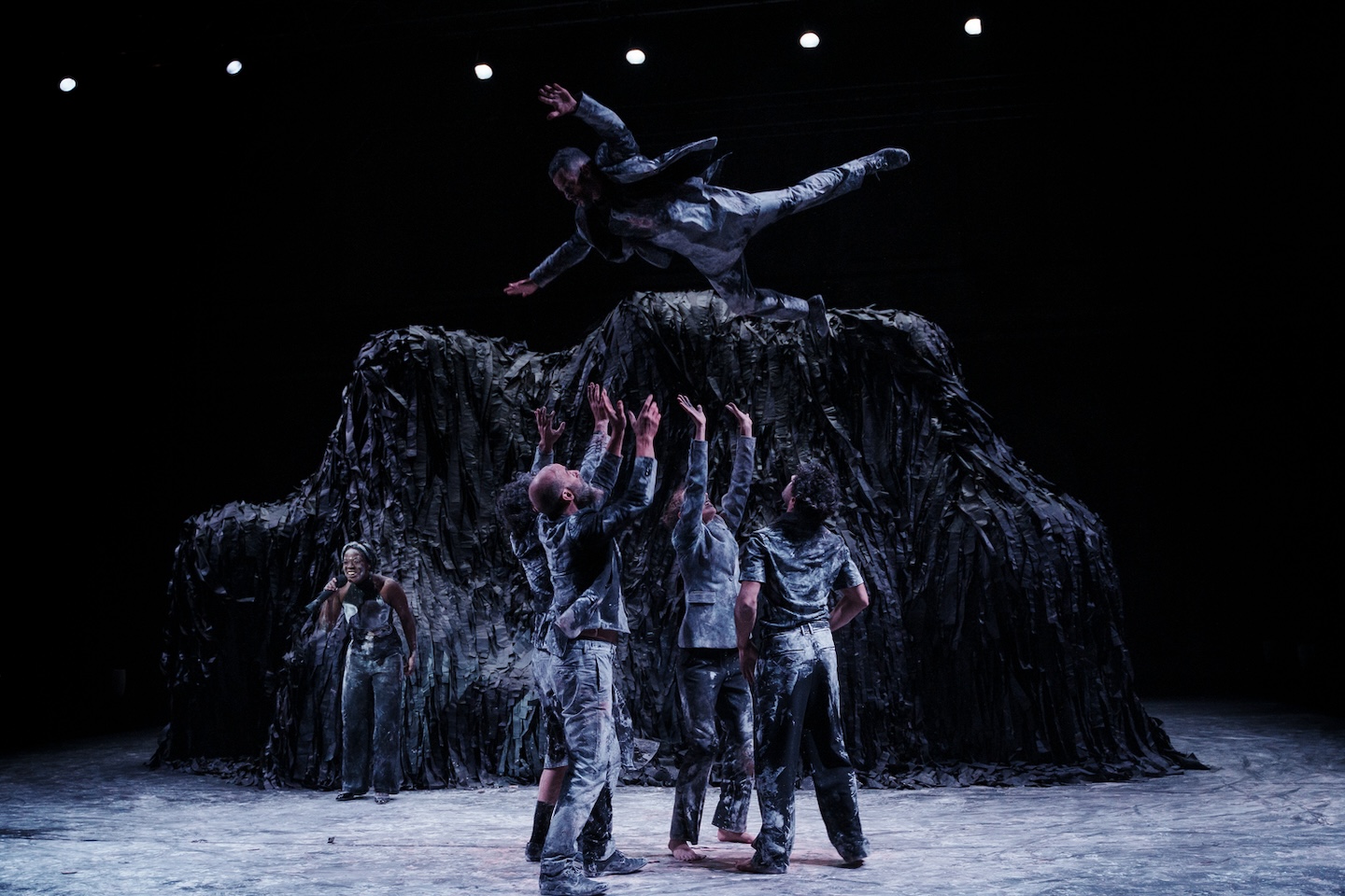 4人の人を1人の人が両手両足を広げて飛んでいる様子