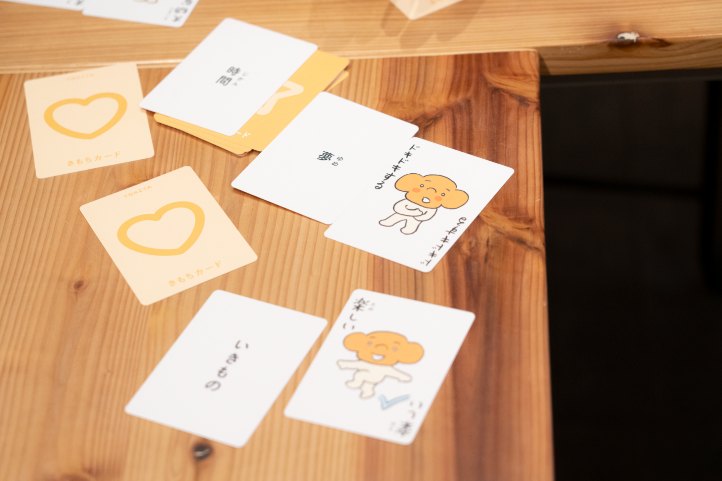 【写真】シンプルなイラストと日本語の言葉が描かれている数枚のカードが、無造作に机に広がっている