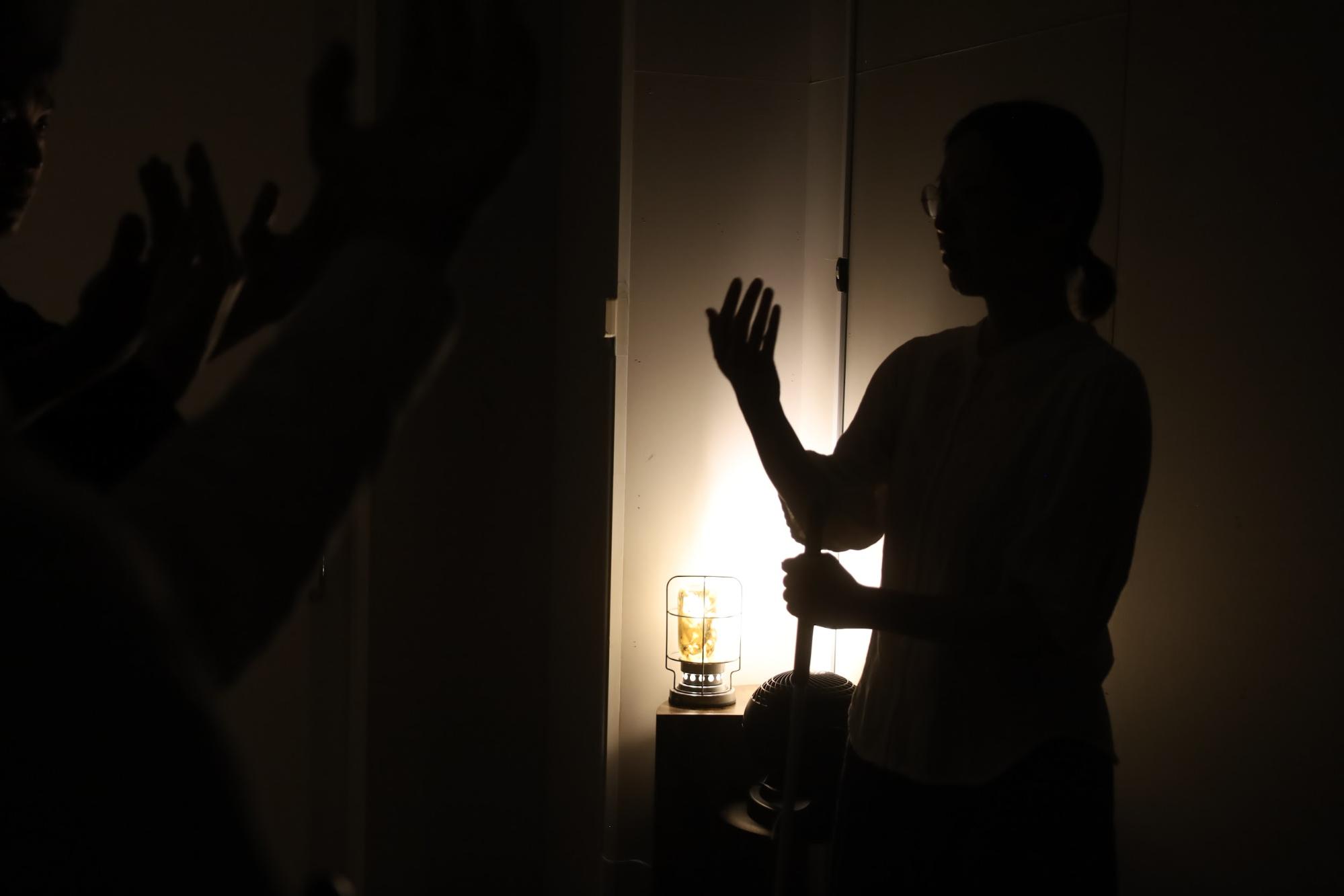 【画像】暗闇の中、小さな照明を灯して話をする人