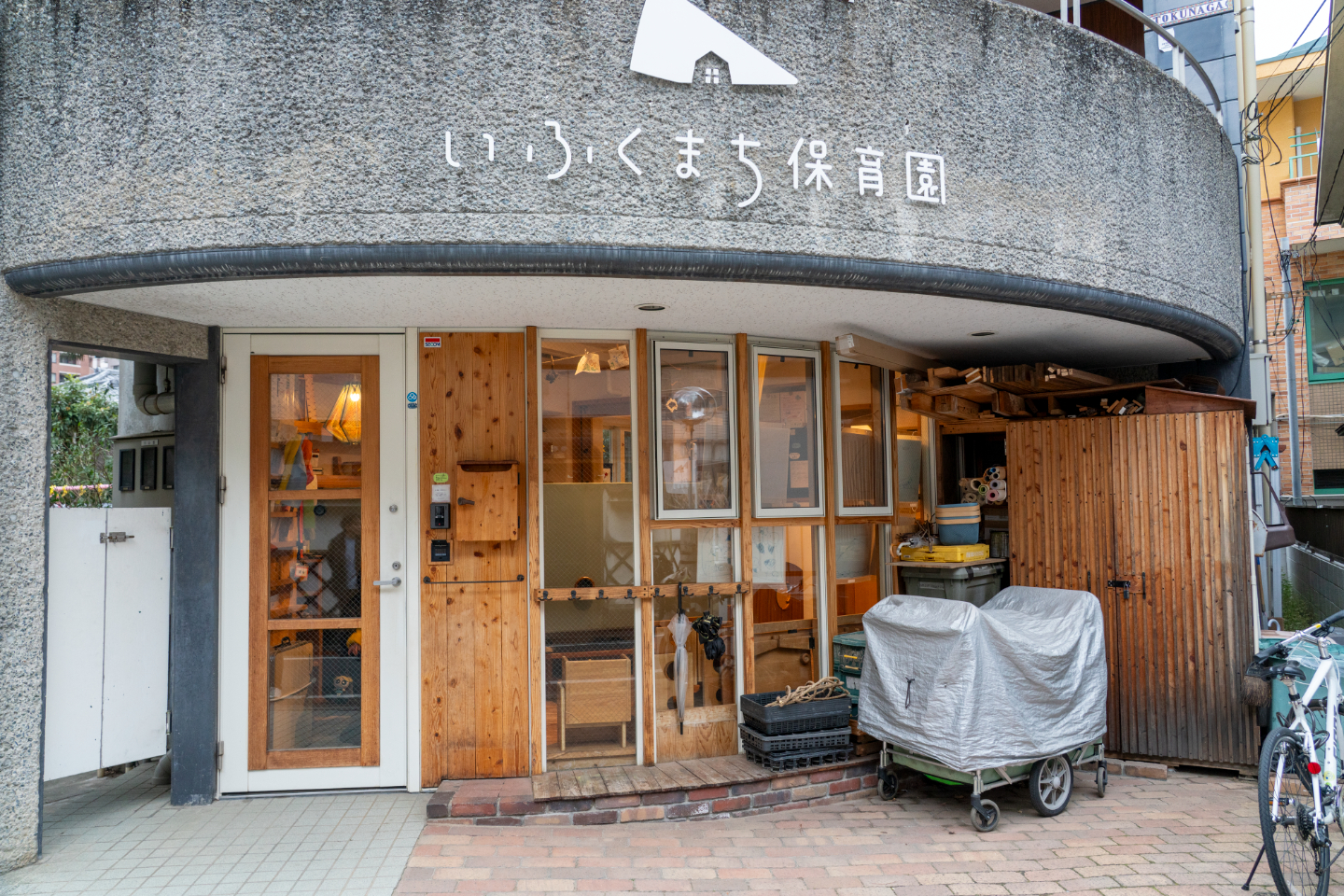 【写真】いふくまち保育園、というサインが掲げられた、石と木の園舎