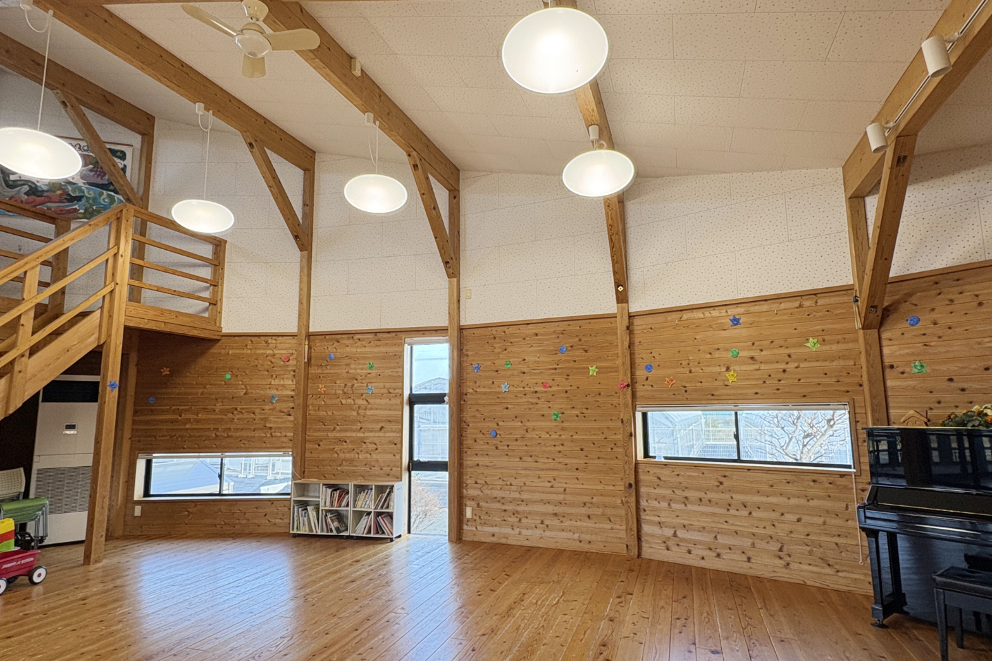 【写真】ホールのような建物の内観。ピアノや、中二階に向かう階段が見える