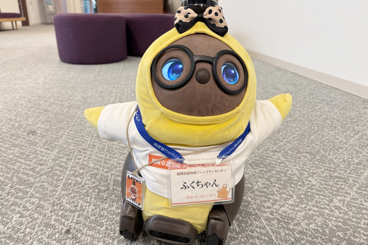 【写真】地面からこちらを見上げて手をあげるロボット