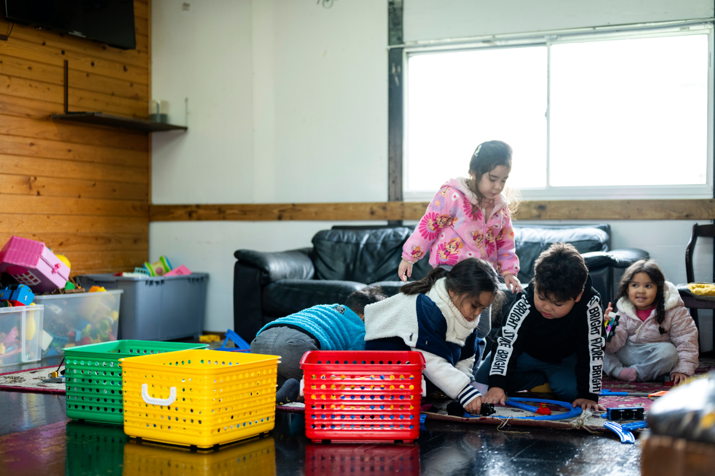【写真】室内のプレイルームで、子どもたちが床に座り、おもちゃの線路で遊んでいる