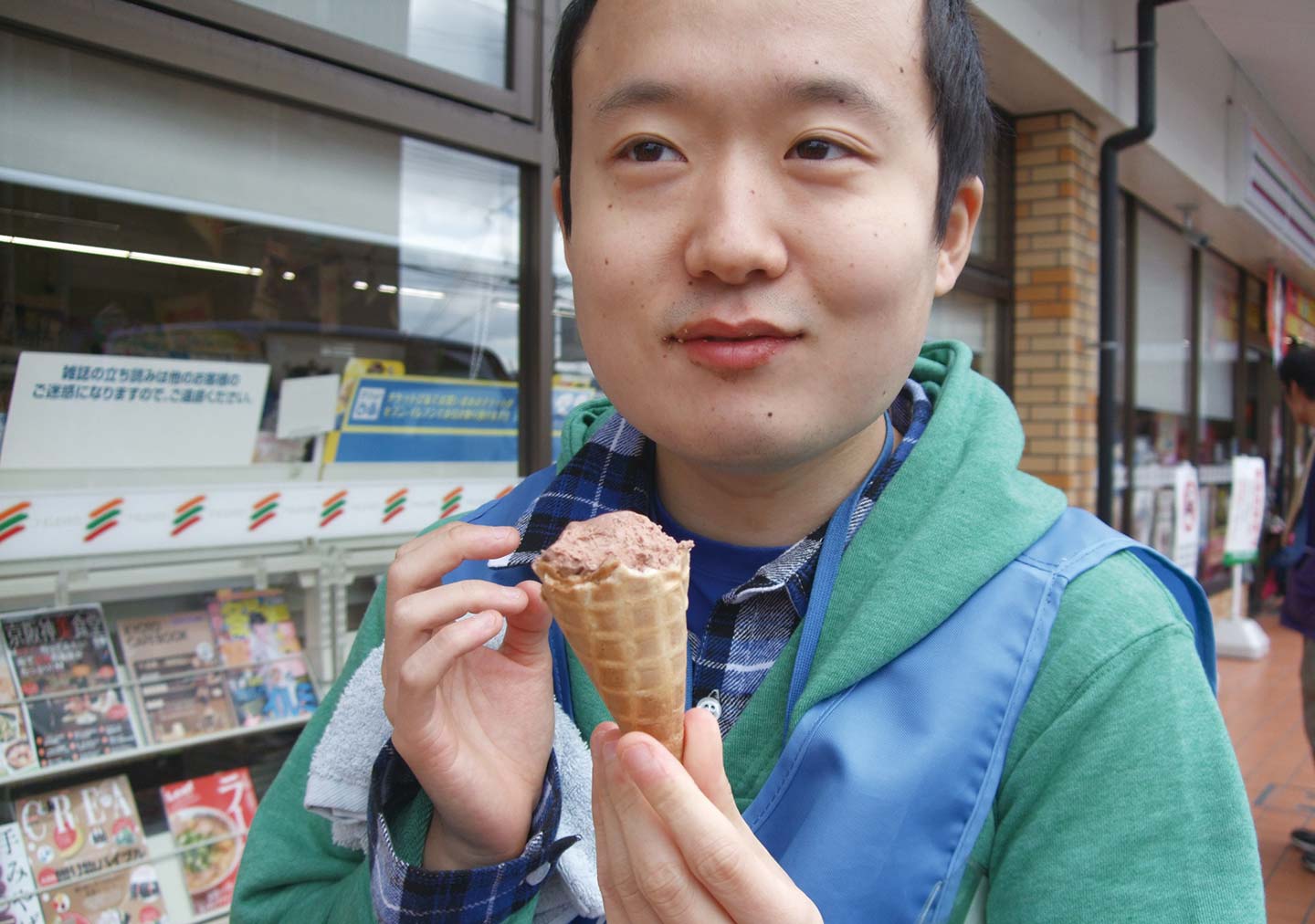 コンビニの前でアイスクリームを嬉しそうに手にする岩木さんの写真。
