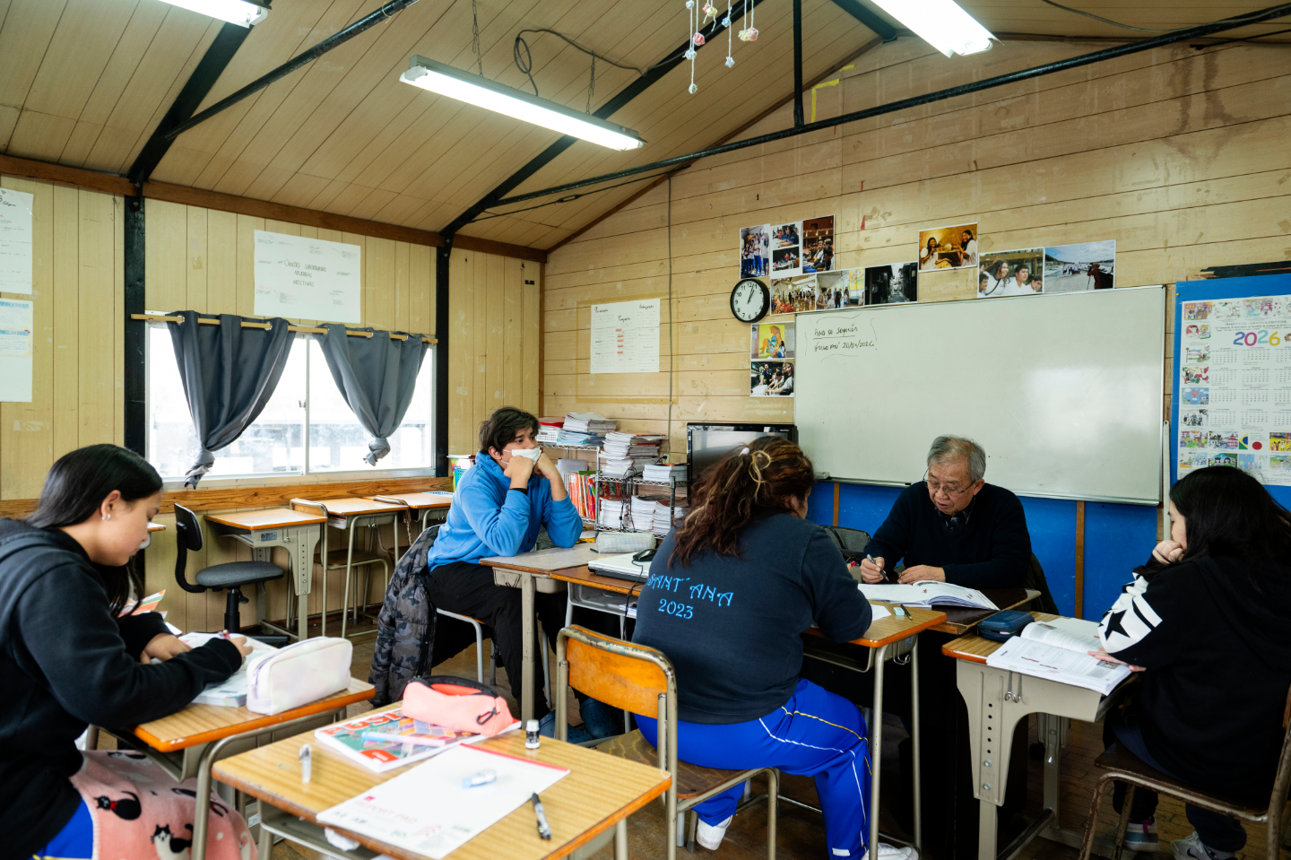 【写真】若者たちが机を囲み授業を受けている
