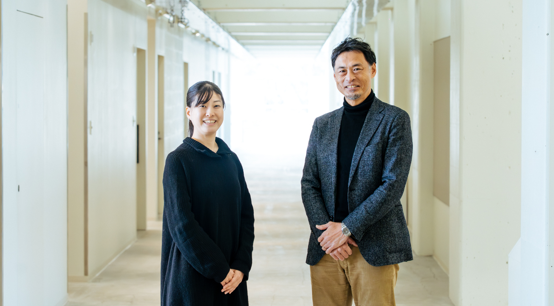 【写真】廊下に立ち、こちらを振り向く2人