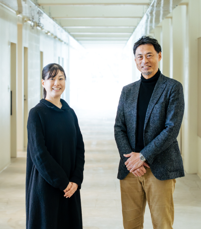 【写真】廊下に立ち、こちらを振り向く2人