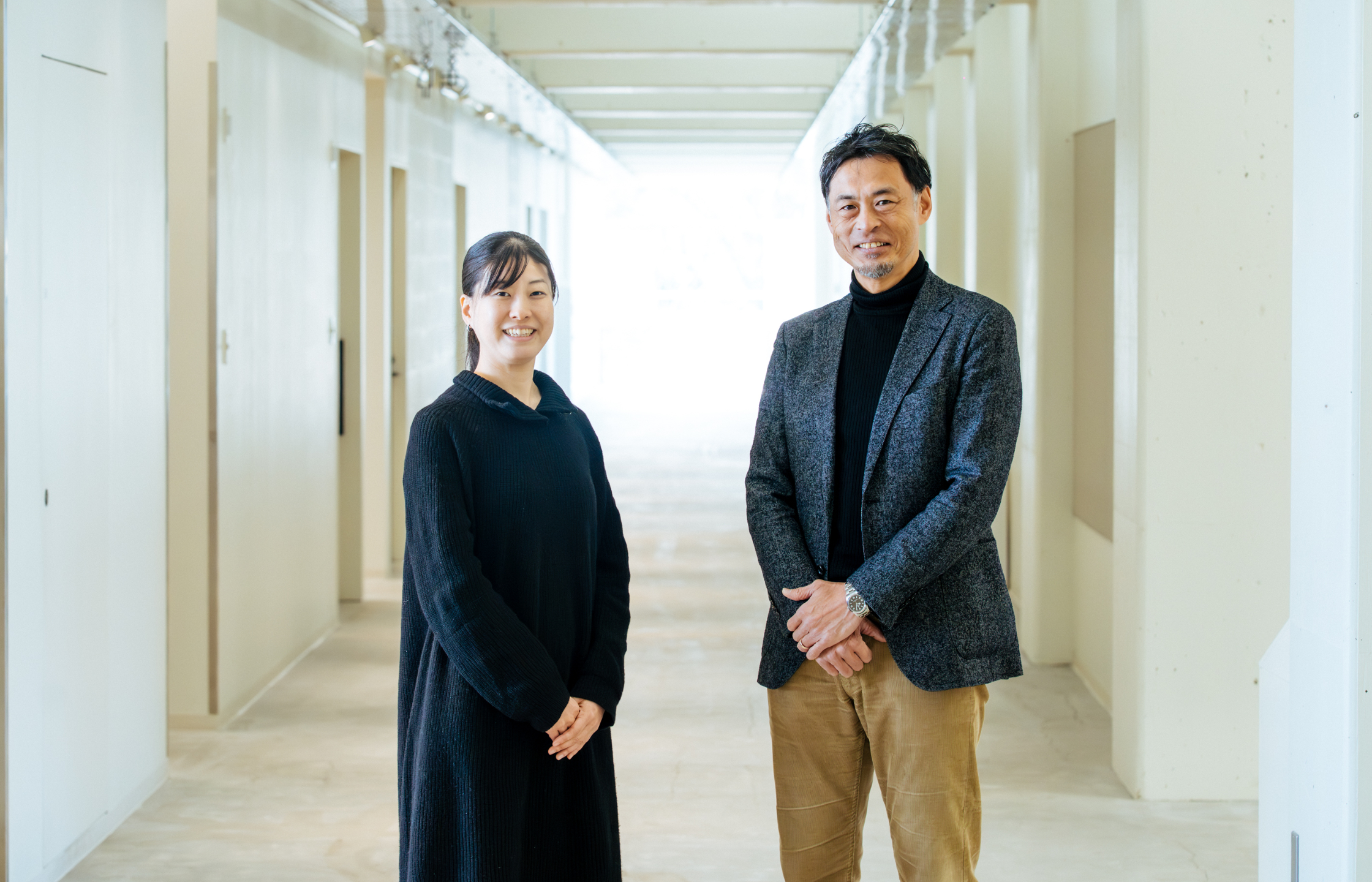 【写真】廊下に立ち、こちらを振り向く2人