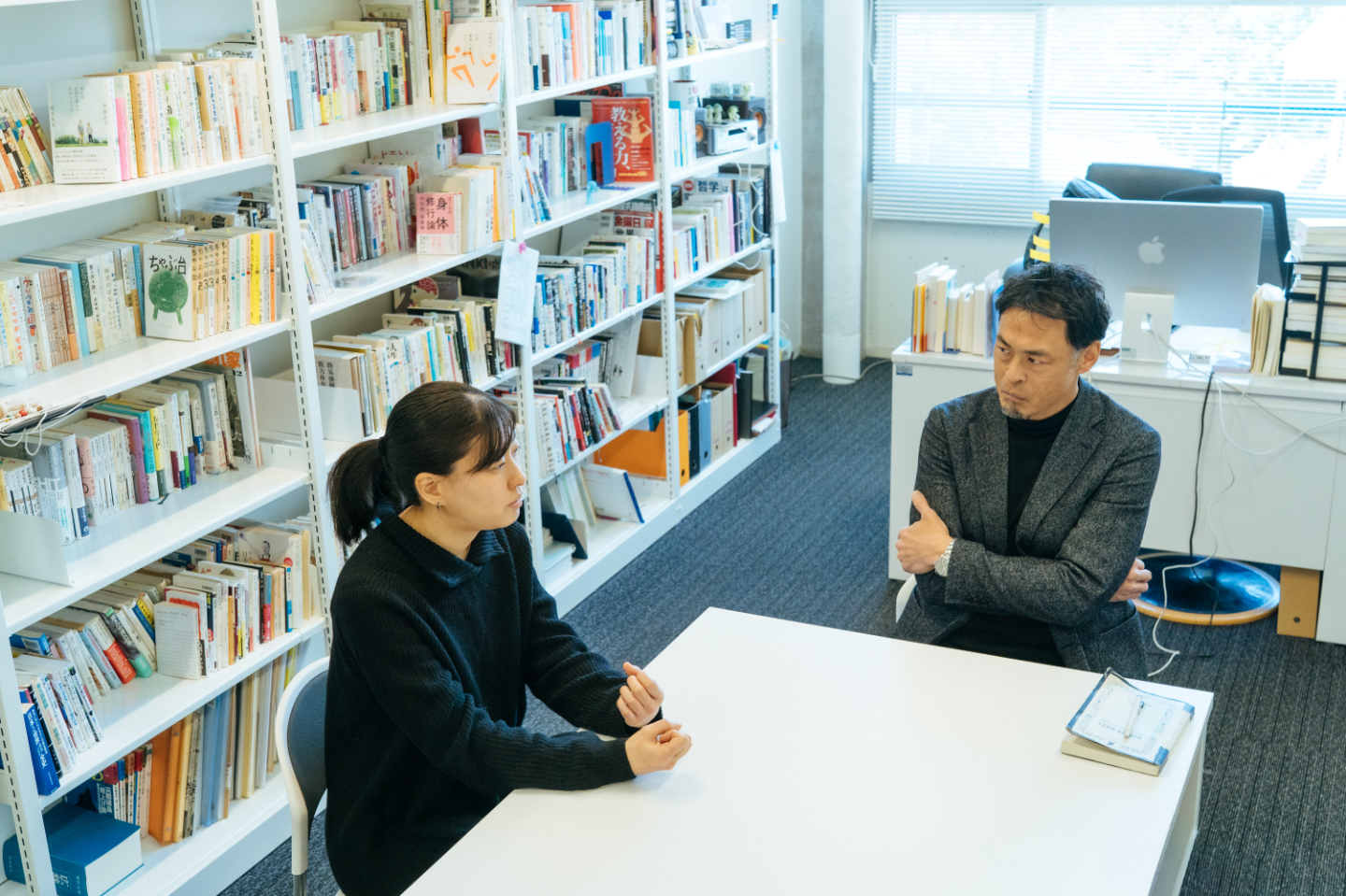 【写真】研究室の机を挟んで、語り合う2人