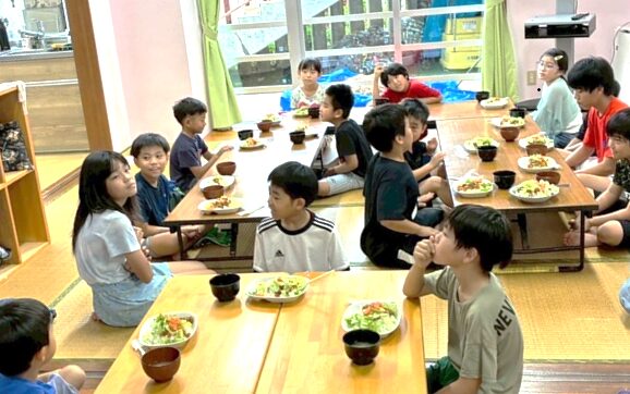 【写真】長テーブルにつくたくさんの子どもたち