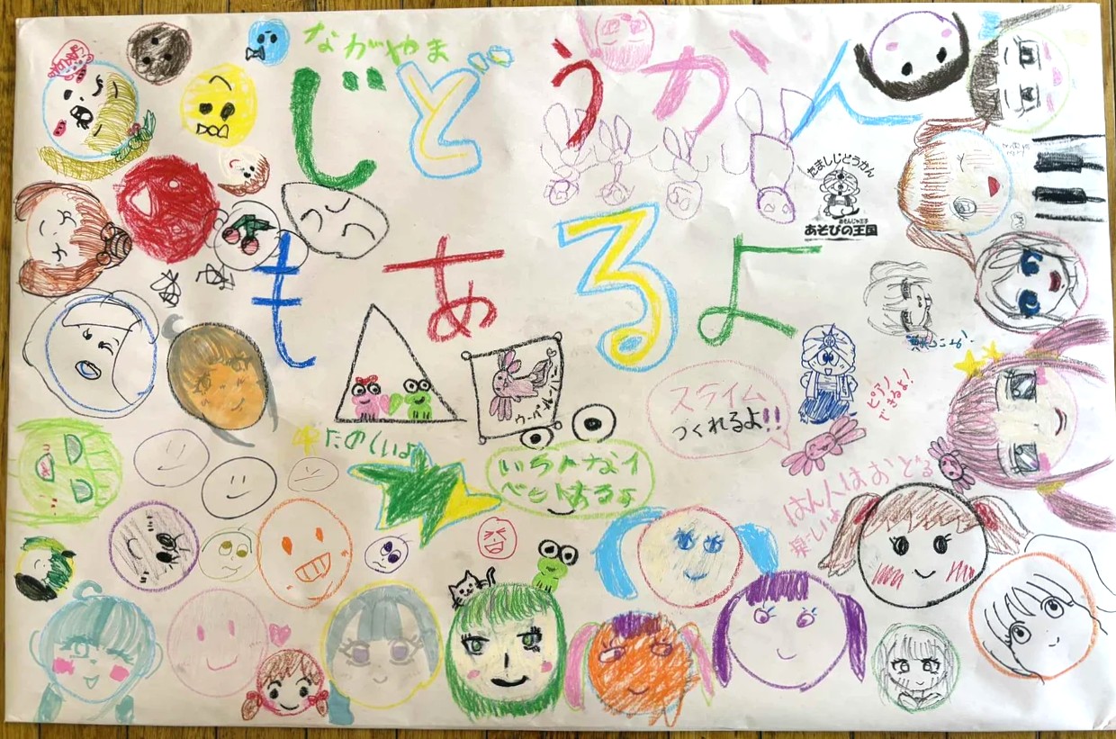 【写真】おおきな模造紙に、じどうかんもあるよ、という文字と、たくさんの似顔絵