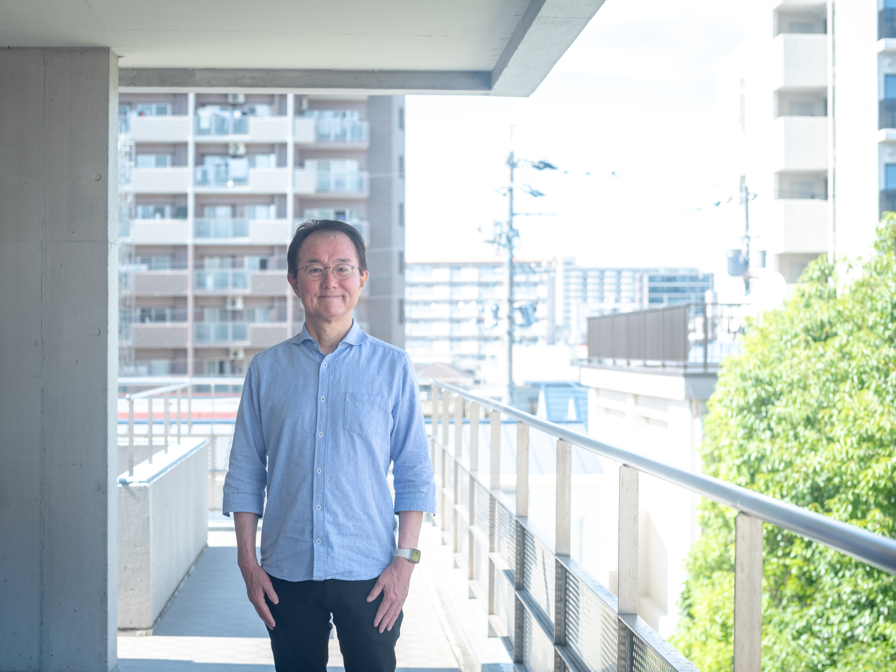 【写真】水色のシャツを着ているみずたにさん。メガネをかけている。