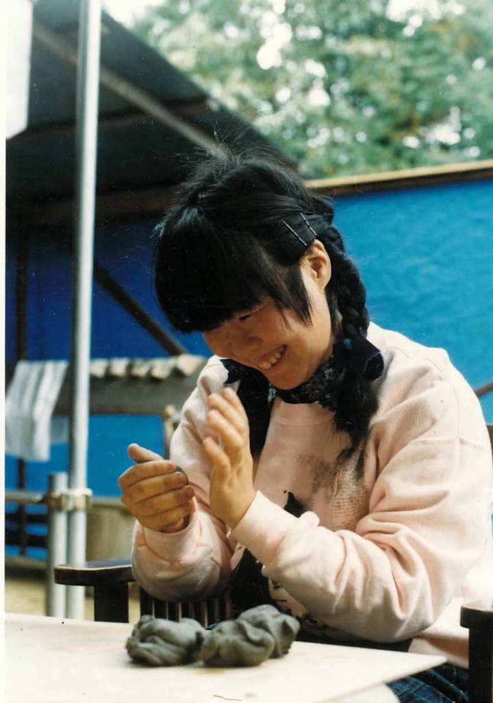 【写真】両手を使って、笑顔で粘土をこねている様子